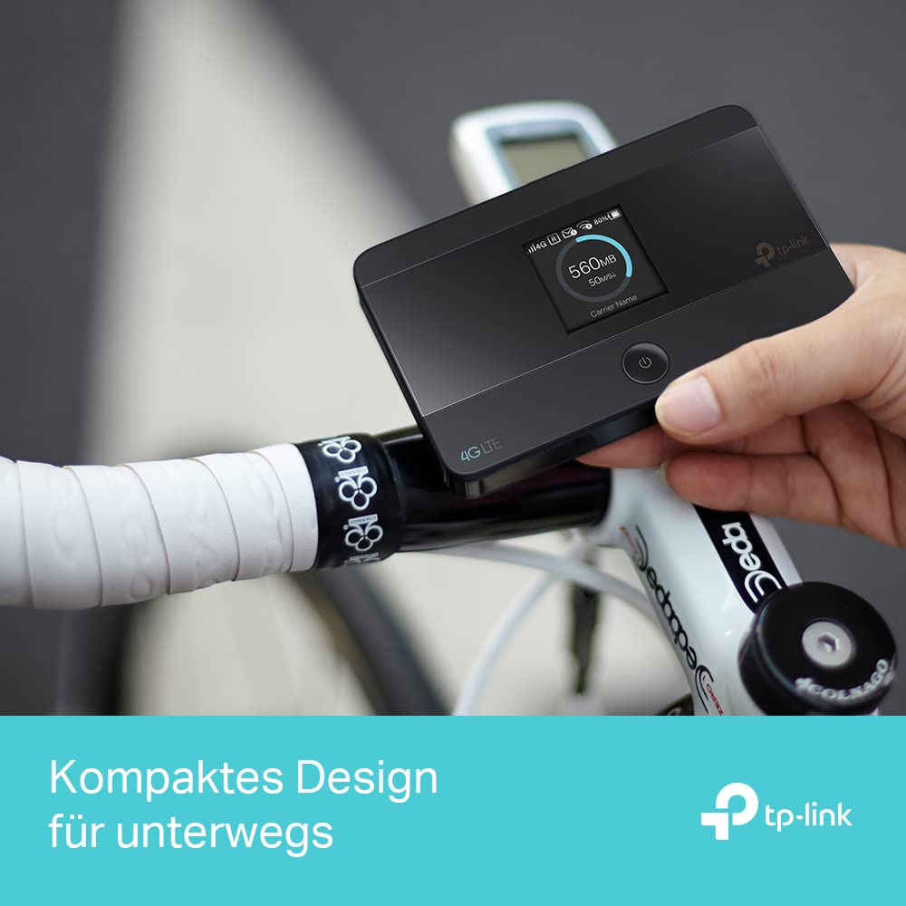 Una mano tiene un router TP-Link 4G LTE nero sopra il manubrio di una bicicletta bianca.