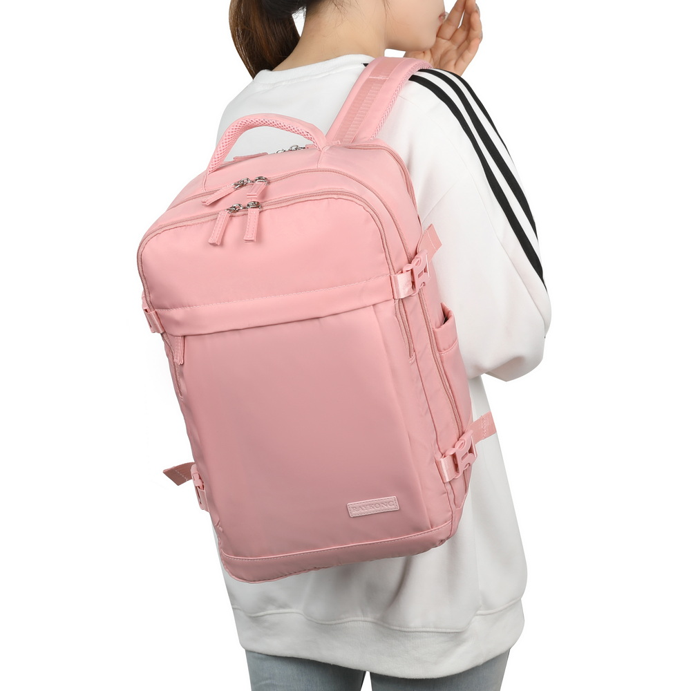Una persona lleva una mochila grande de color rosa claro con múltiples compartimentos y correas en la espalda.