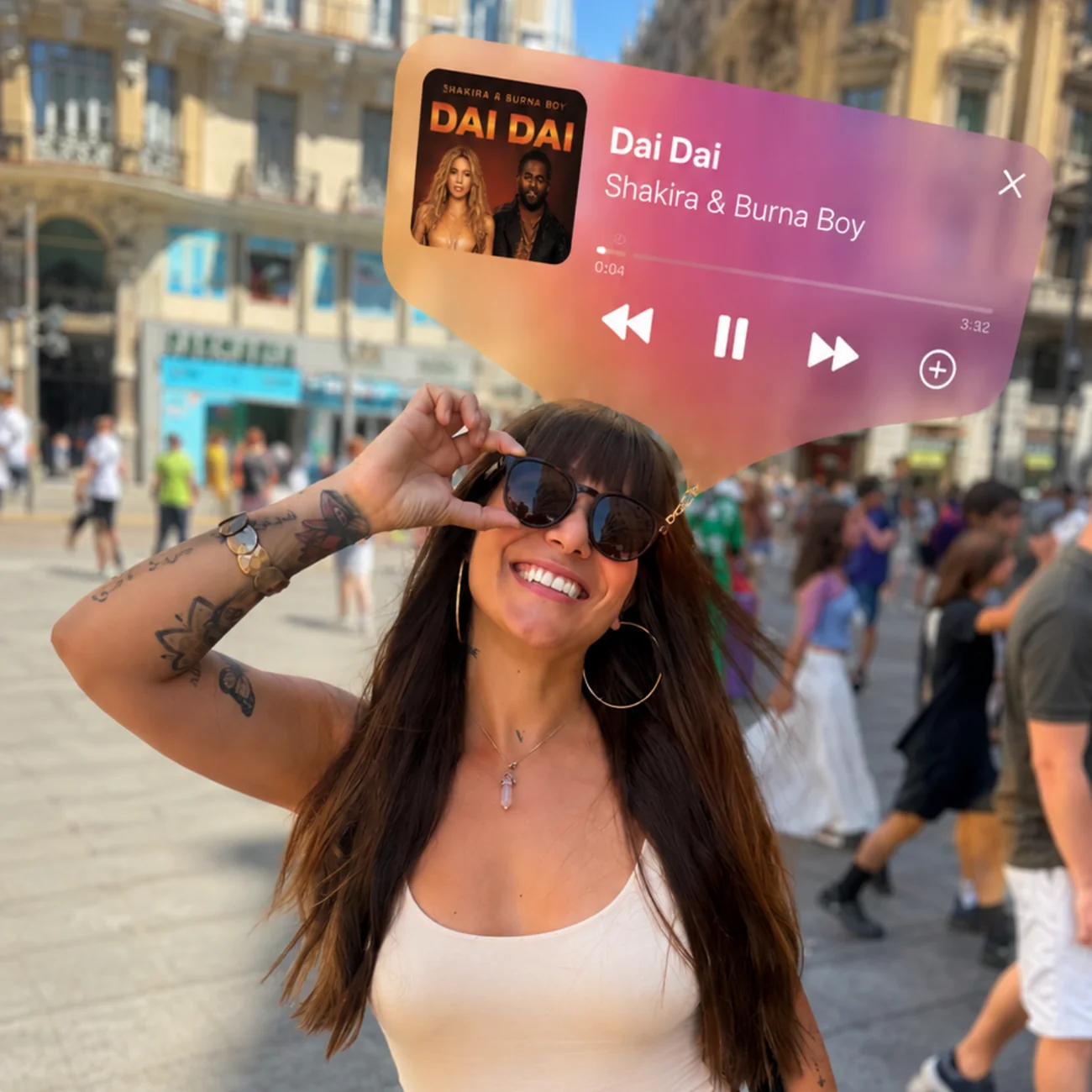 Mujer sonriente con gafas de sol y tatuajes posa en una plaza, con una interfaz de reproductor flotando.