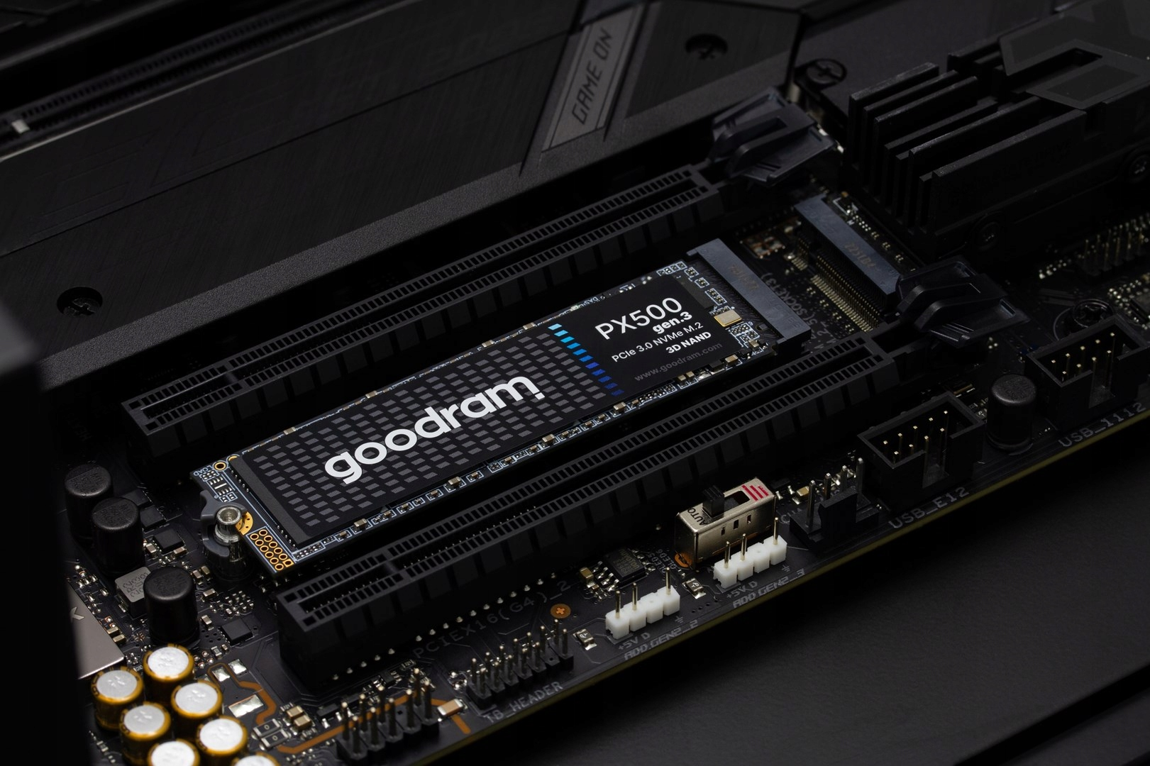 A Goodram PX500 Gen.3 NVMe M.2 SSD is plugged into an M.2 slot on a black computer motherboard.