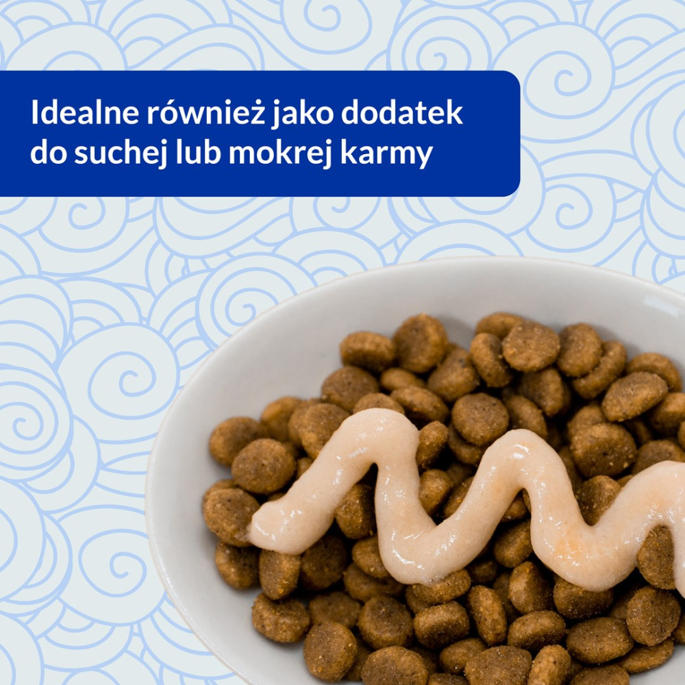 Biala miska z suchą karmą i polewą z jasnego sosu na wierzchu.