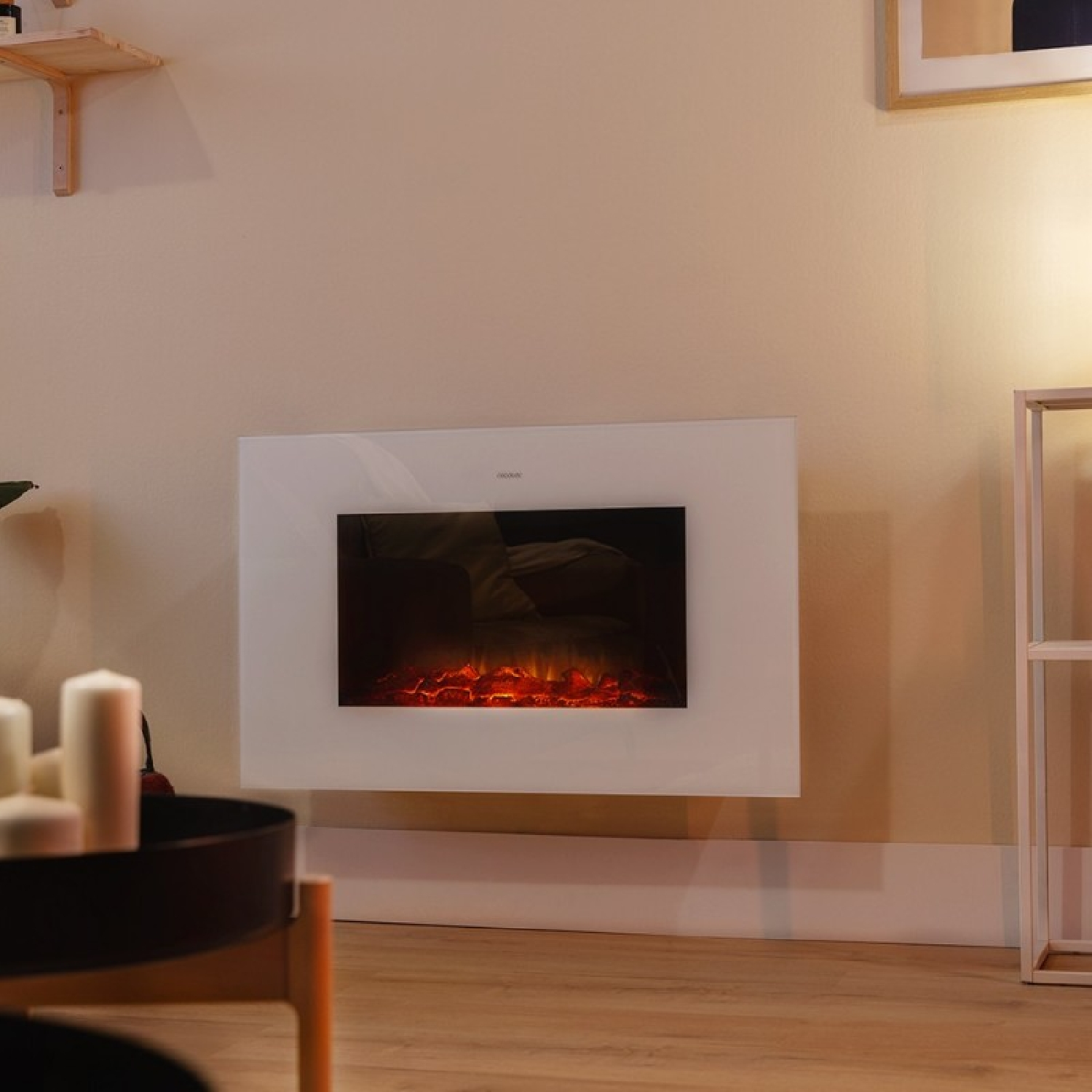 Una chimenea de pared blanca con ascuas brillantes en una pared beige en una habitación con suelo de madera.
