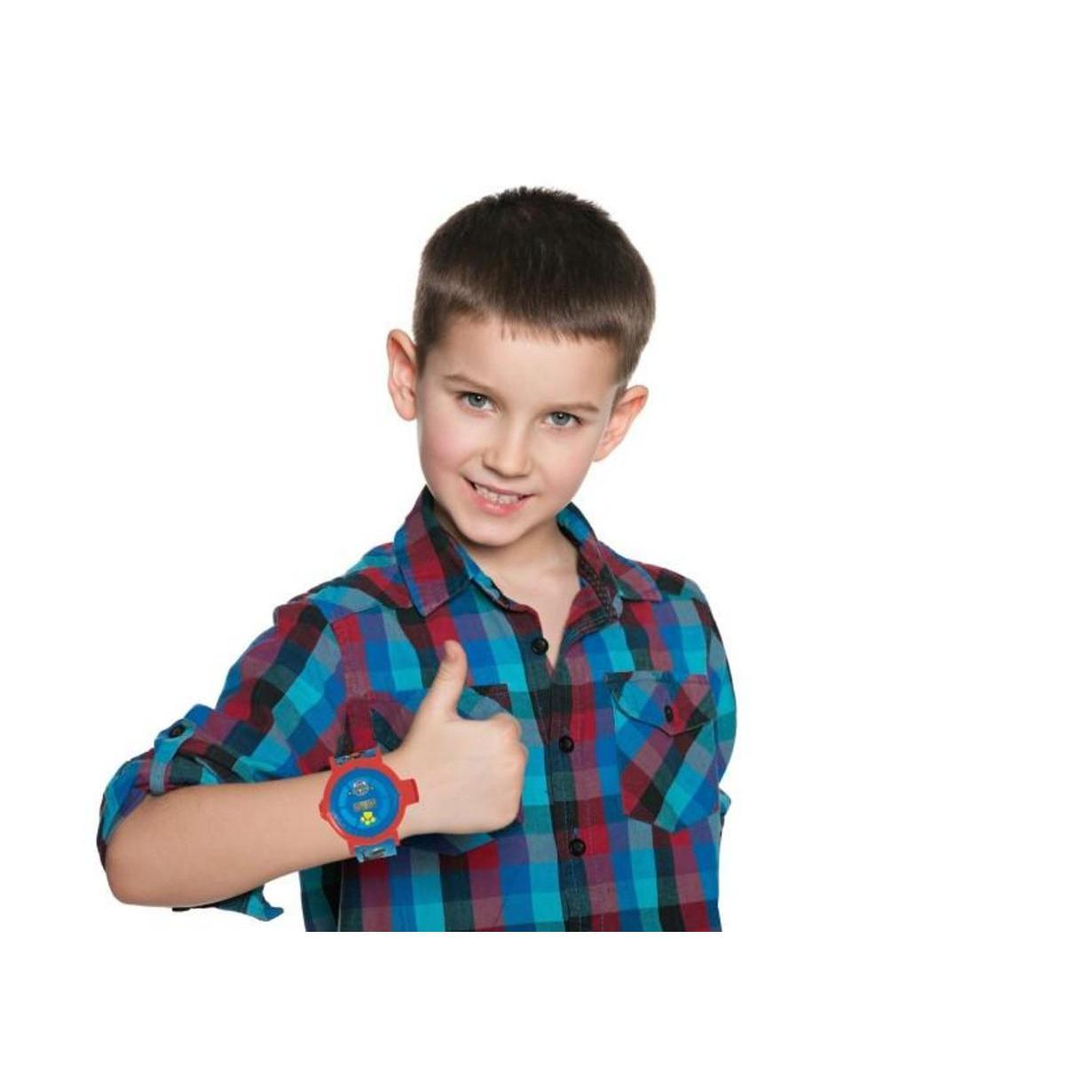 Ein Junge im karierten Hemd zeigt den Daumen nach oben und trägt eine rote Uhr.