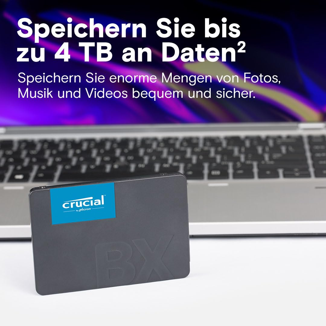 Un SSD Crucial BX si trova davanti a un laptop con testo promozionale sullo sfondo.