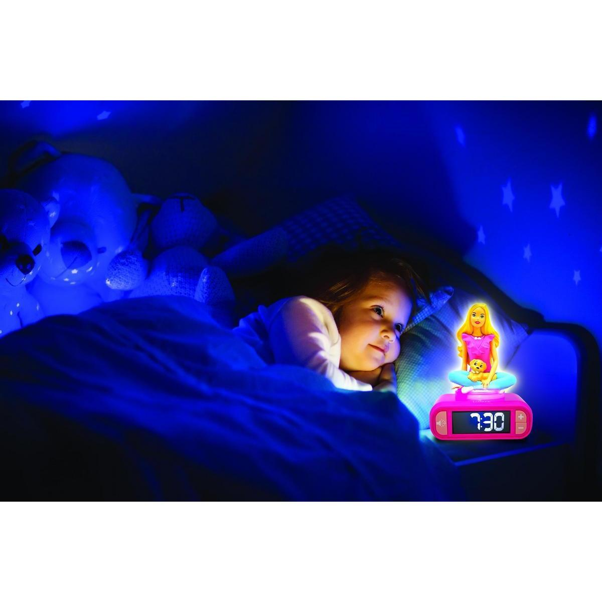 Un niño está en la cama con luz azul, un reloj Barbie y peluches.