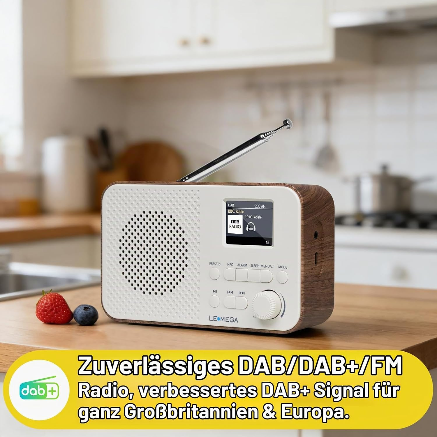 Ein hölzernes DAB-Radio steht auf einem Küchentisch neben einer Erdbeere und einer Blaubeere.