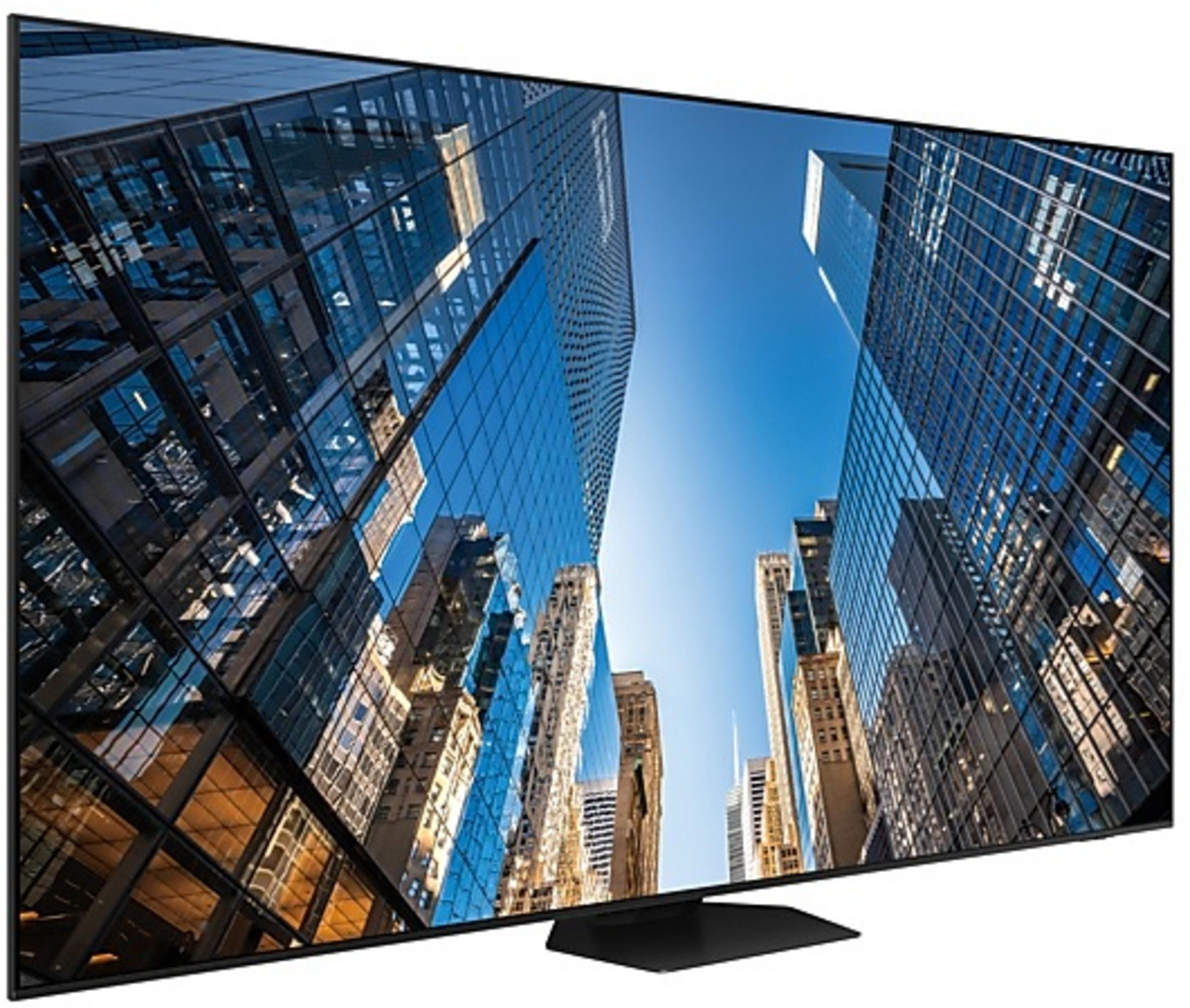 Un televisor de pantalla plana muestra una vista de rascacielos imponentes y cielo azul desde abajo.