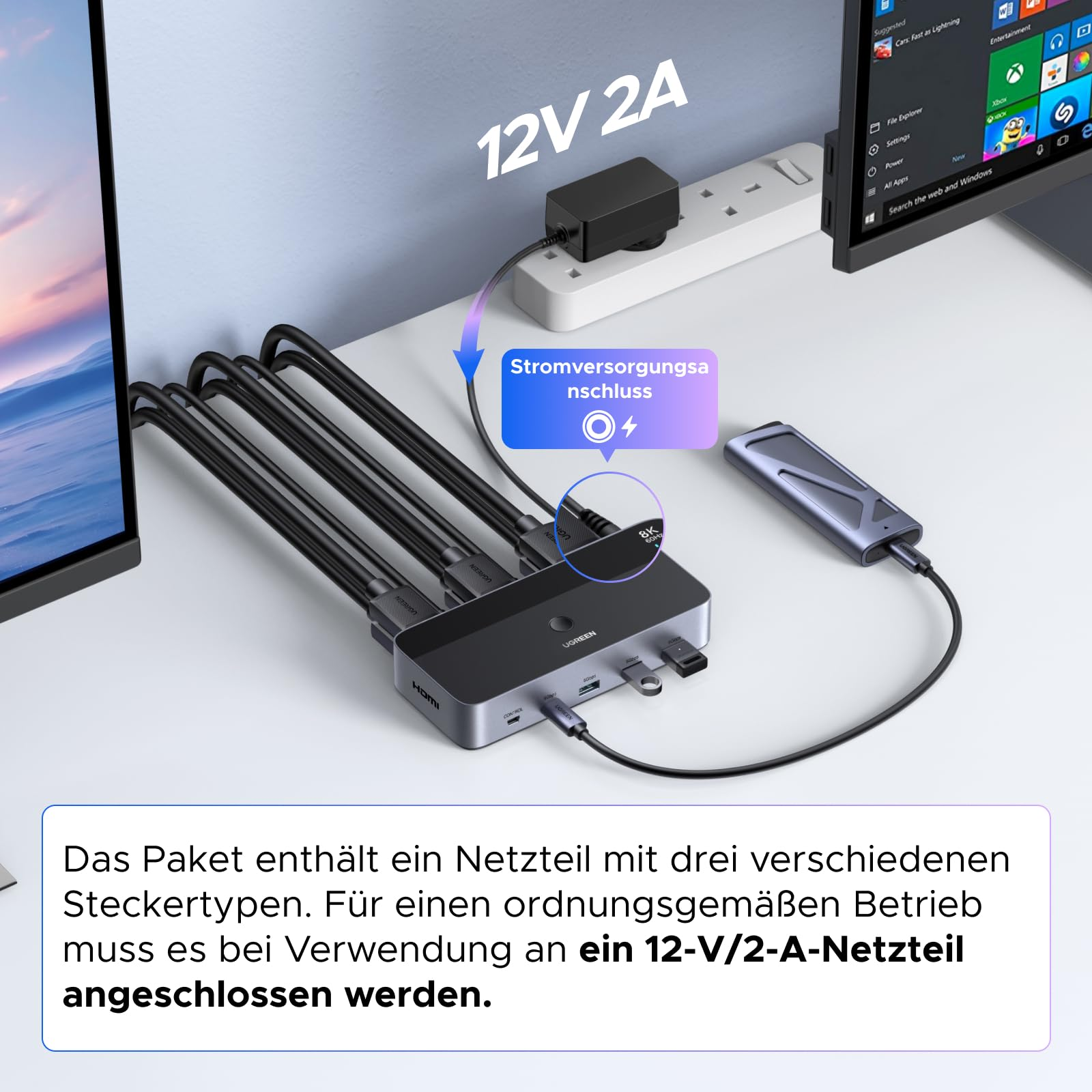 Un hub USB-C UGREEN grigio con cavi collegati e un alimentatore su una scrivania.