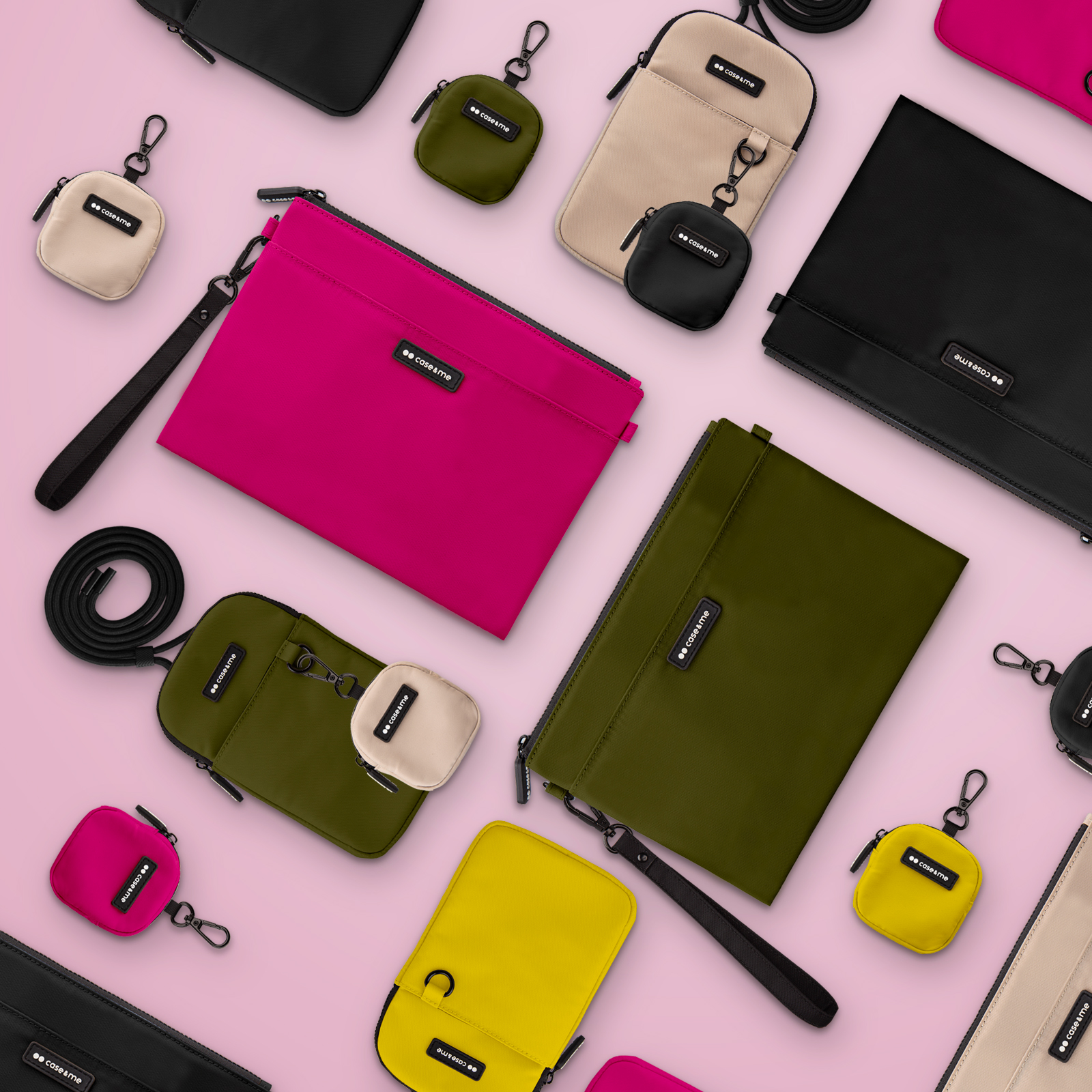 Varios bolsos coloridos y estuches pequeños con el logotipo 'case&me' organizados sobre un fondo rosa.
