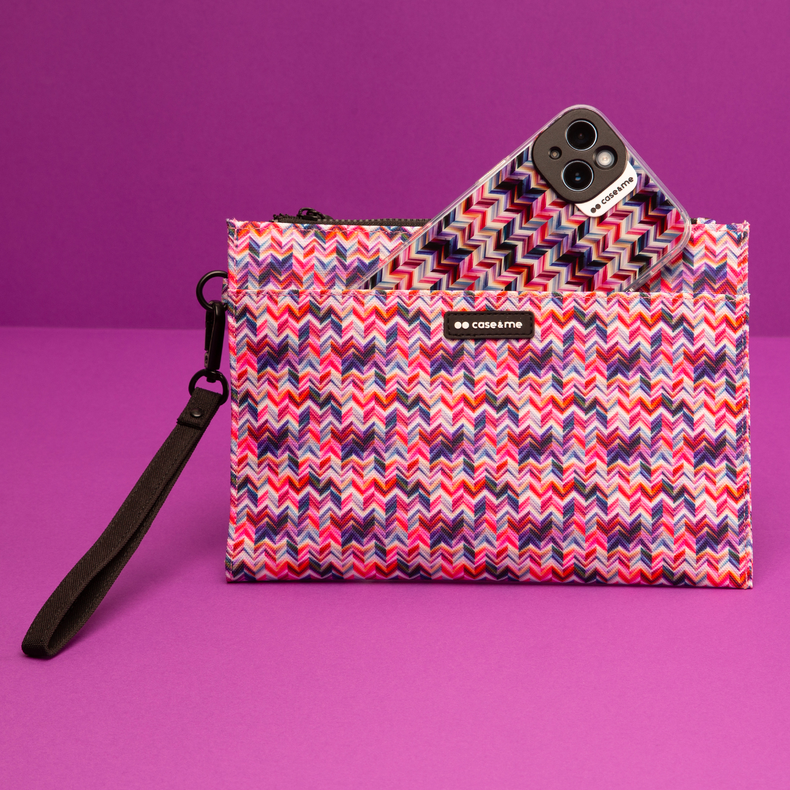 Un bolso colorido con correa de muñeca que contiene un smartphone a juego, sobre un fondo morado.