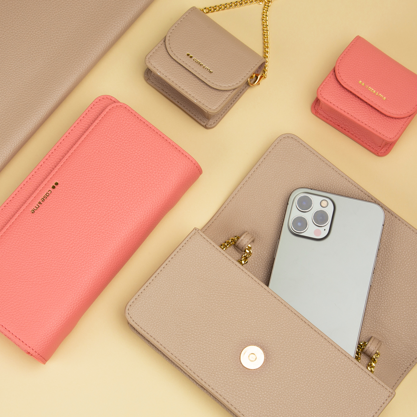 Accesorios de cuero rosa y beige de moda y fundas para teléfonos con cadenas doradas sobre fondo beige.