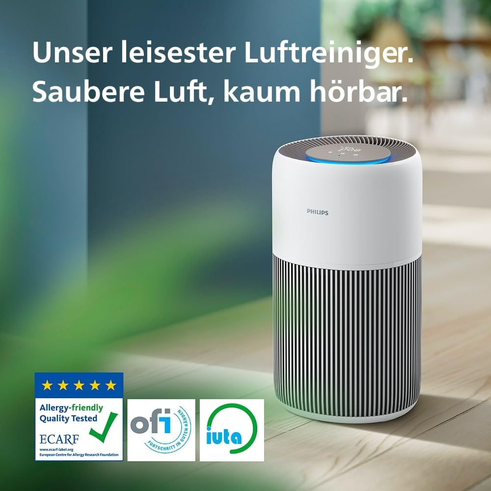 Ein weißer Philips Luftreiniger mit schwarzem Streifenmuster steht auf einem Holzboden in einem Raum.