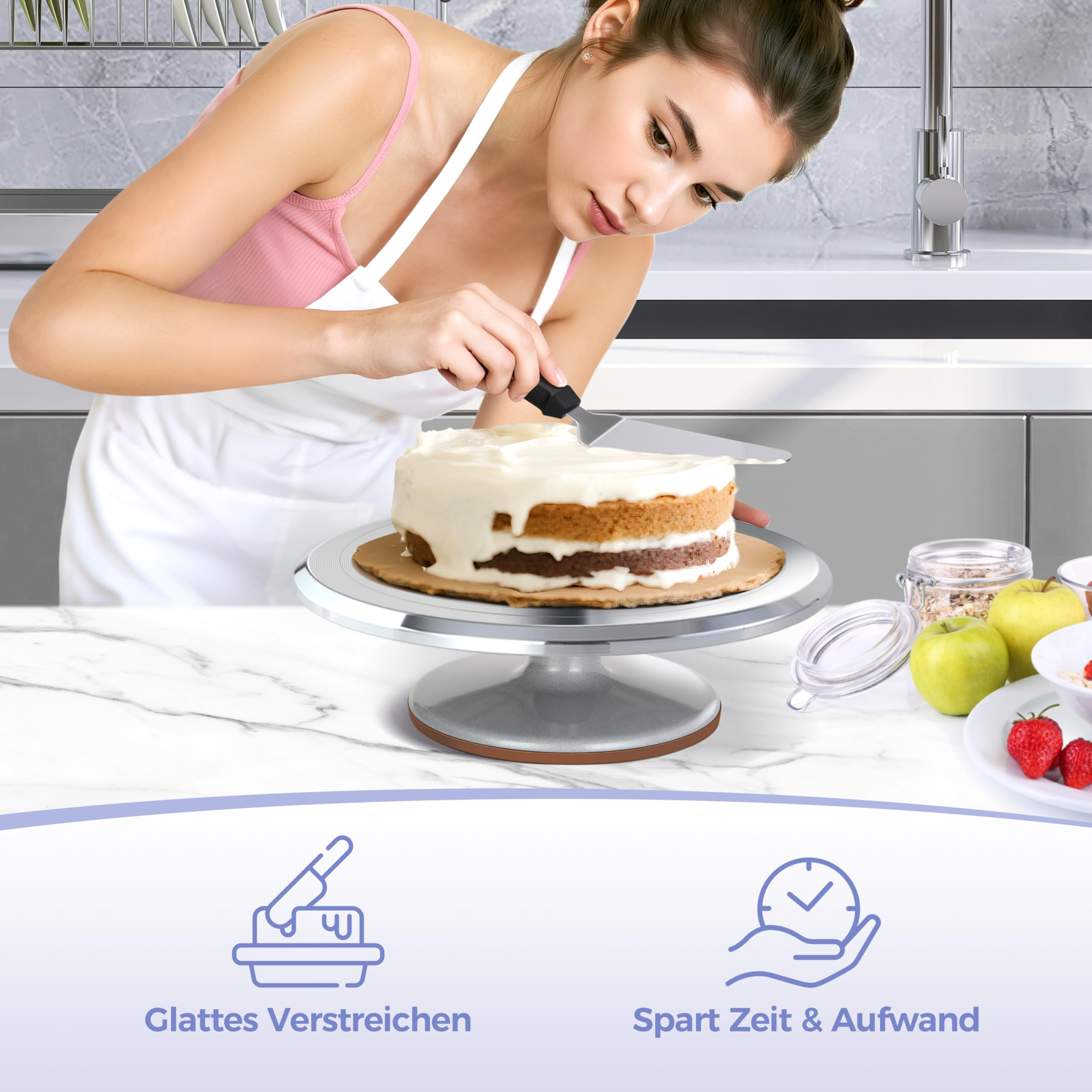 Eine Frau in einer Küche verziert einen zweistöckigen Kuchen auf einem Ständer mit weißer Creme und einem Spatel.