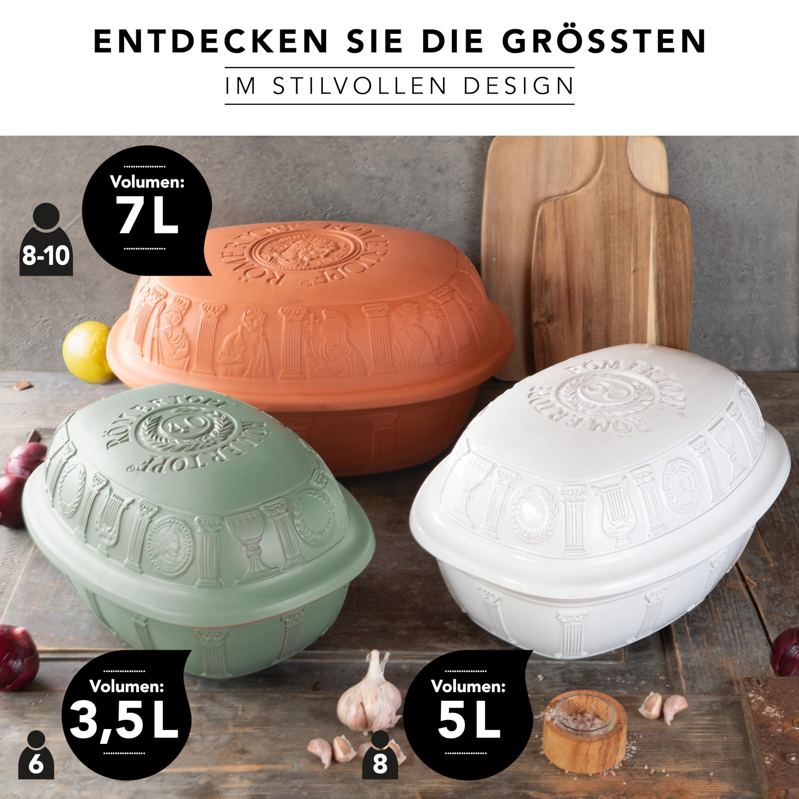 Drei farbige Römertöpfe in Orange, Grün und Weiß stehen mit Holzbrettern und Zutaten auf einem Holztisch.