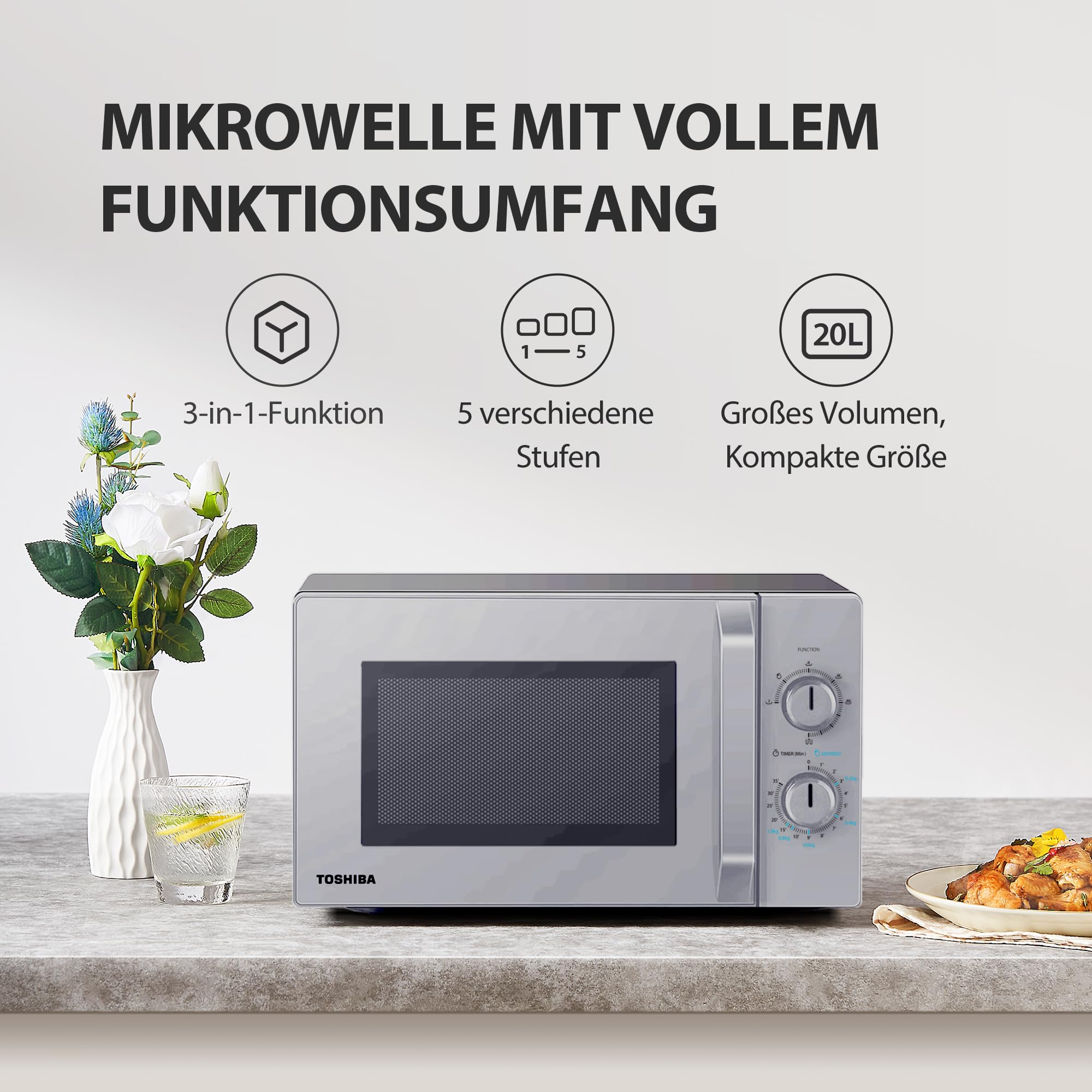Graue Toshiba-Mikrowelle auf einer Arbeitsplatte mit Blumen, einem Glas Wasser und Lebensmitteln.