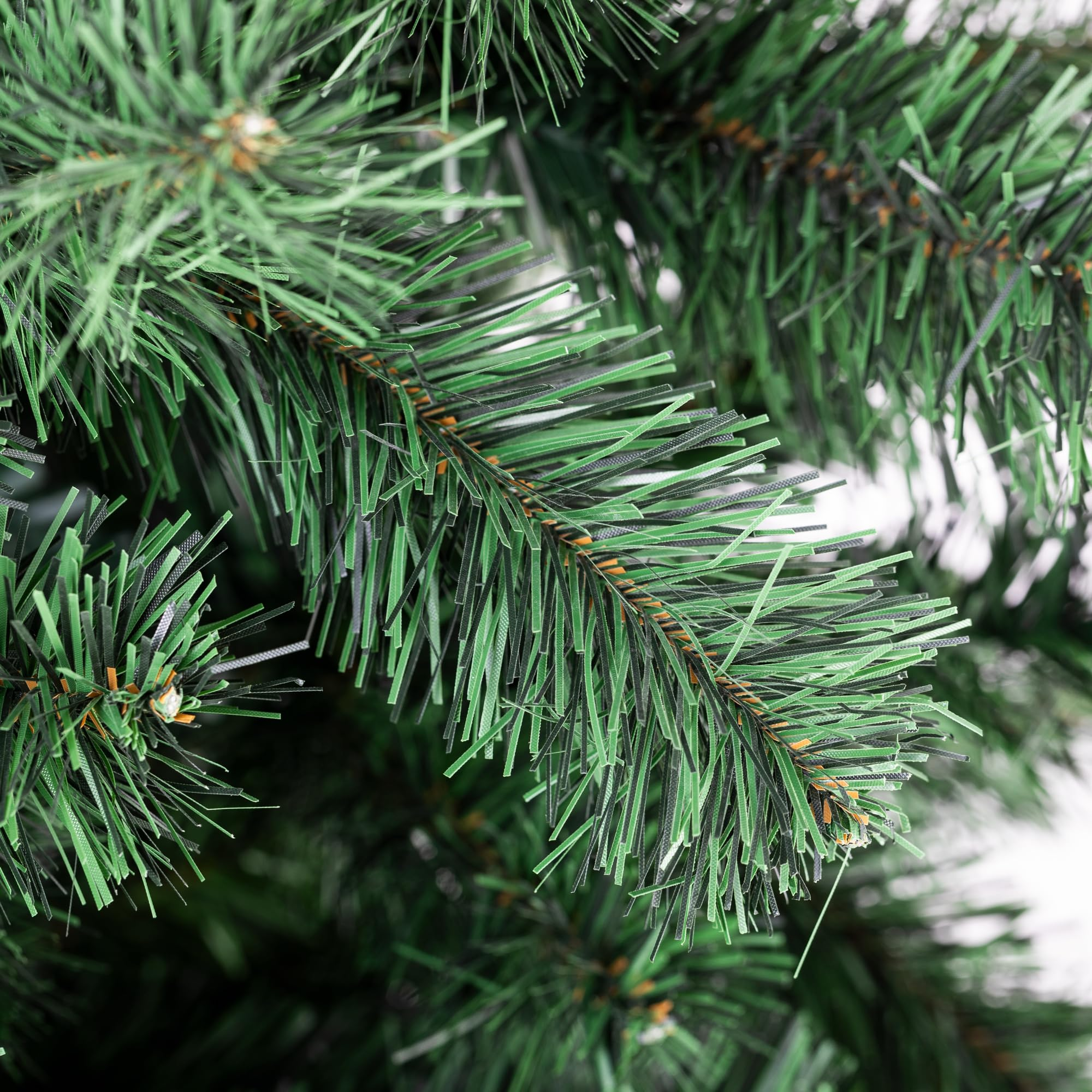 Primo piano degli aghi verdi di un albero di Natale artificiale.