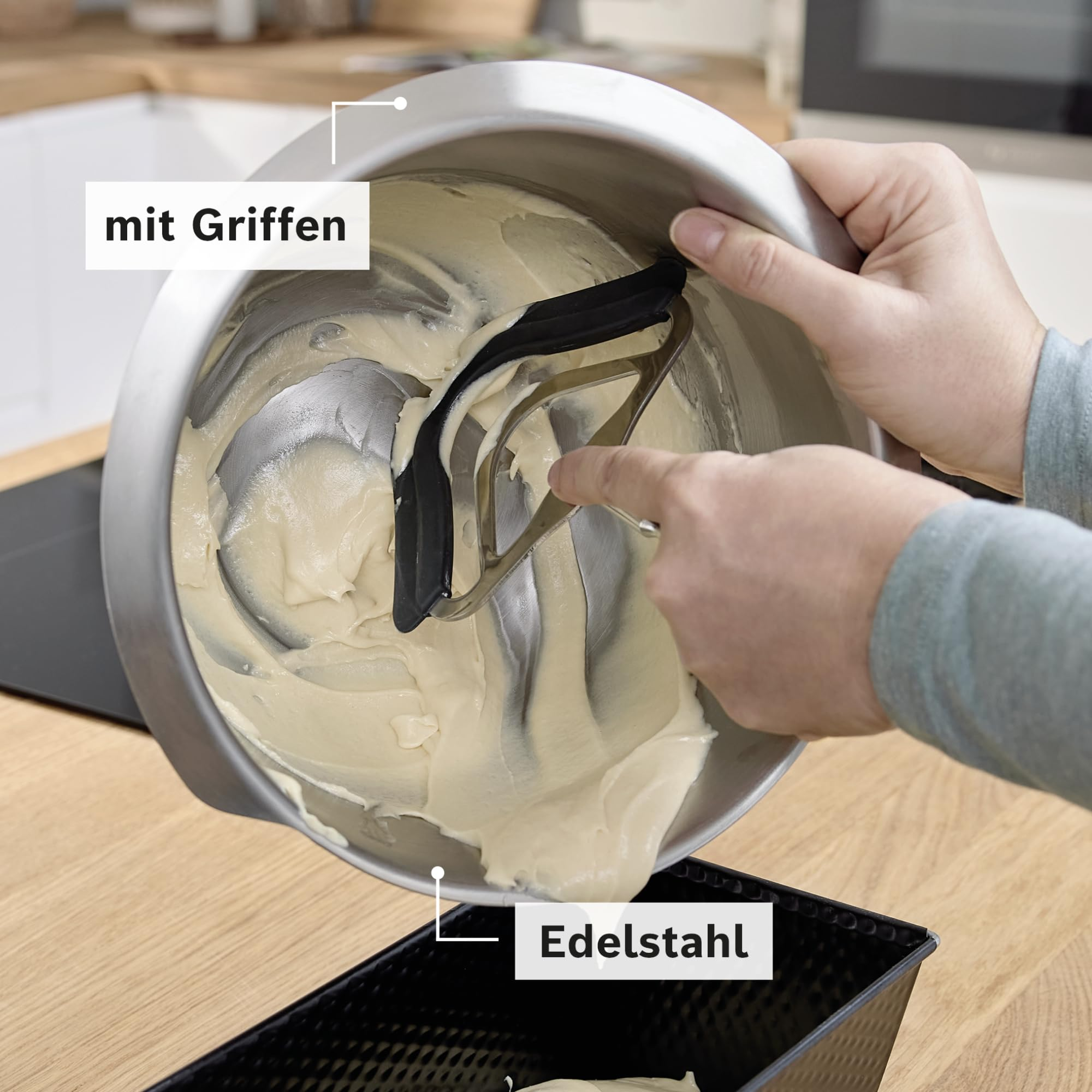 Edelstahlschüssel mit Teig wird in eine Backform gefüllt.