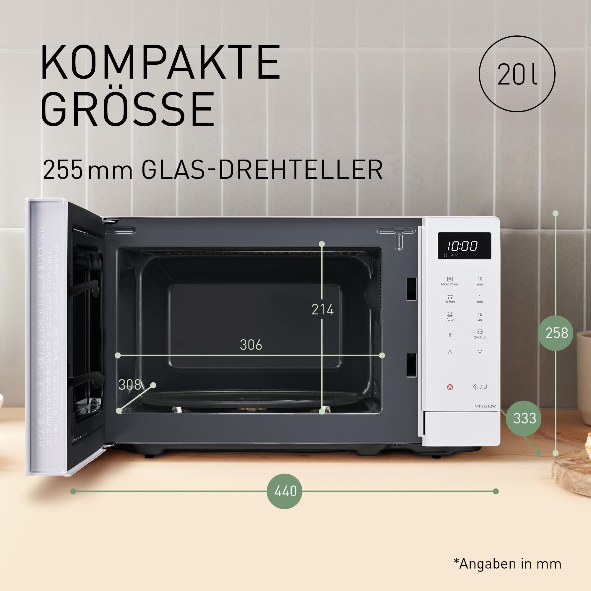 Weisse Mikrowelle mit geoeffneter Tuer und Massangaben auf Holztheke vor Fliesenwand.