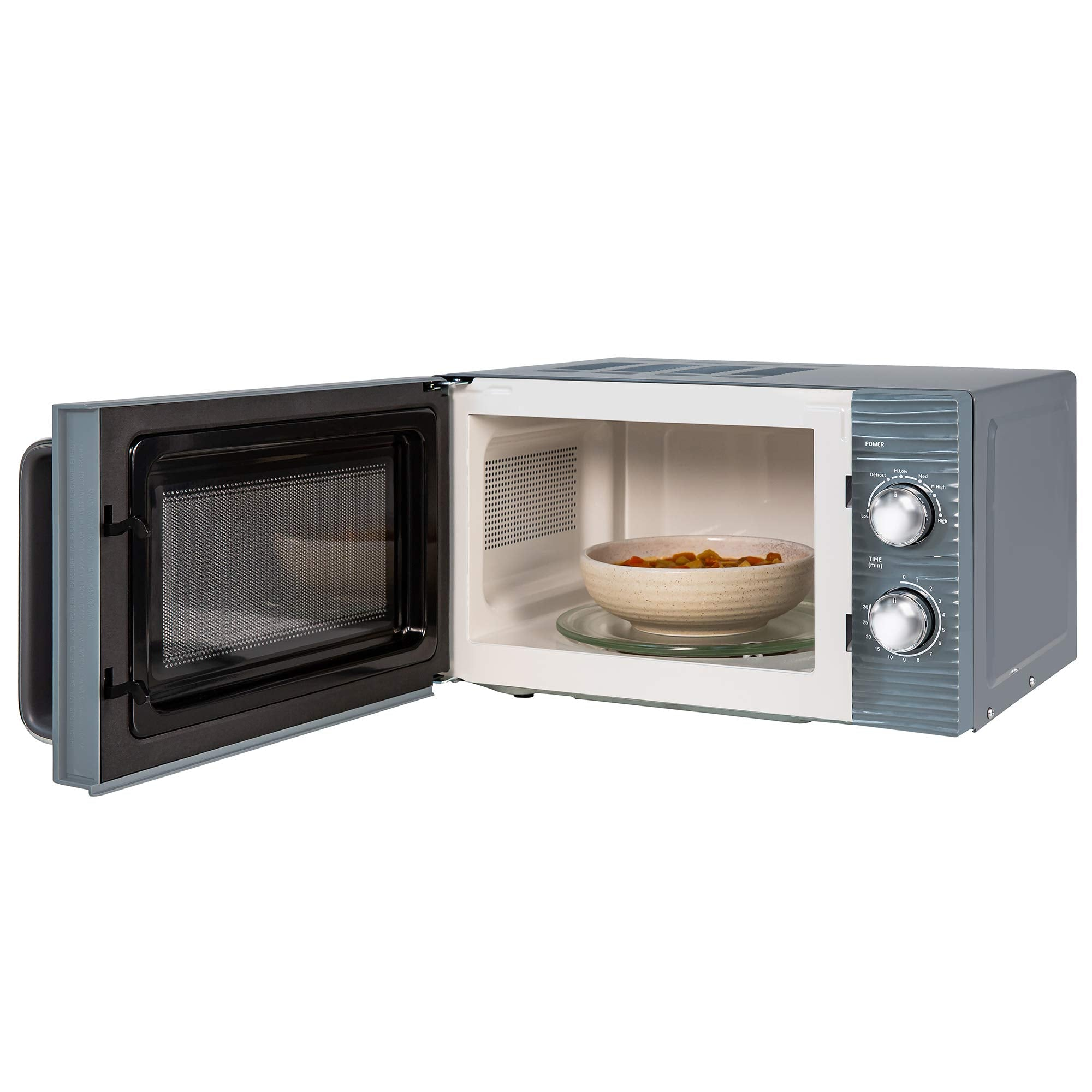 Un micro-ondes gris avec une porte ouverte et un bol de soupe sur le plateau tournant.