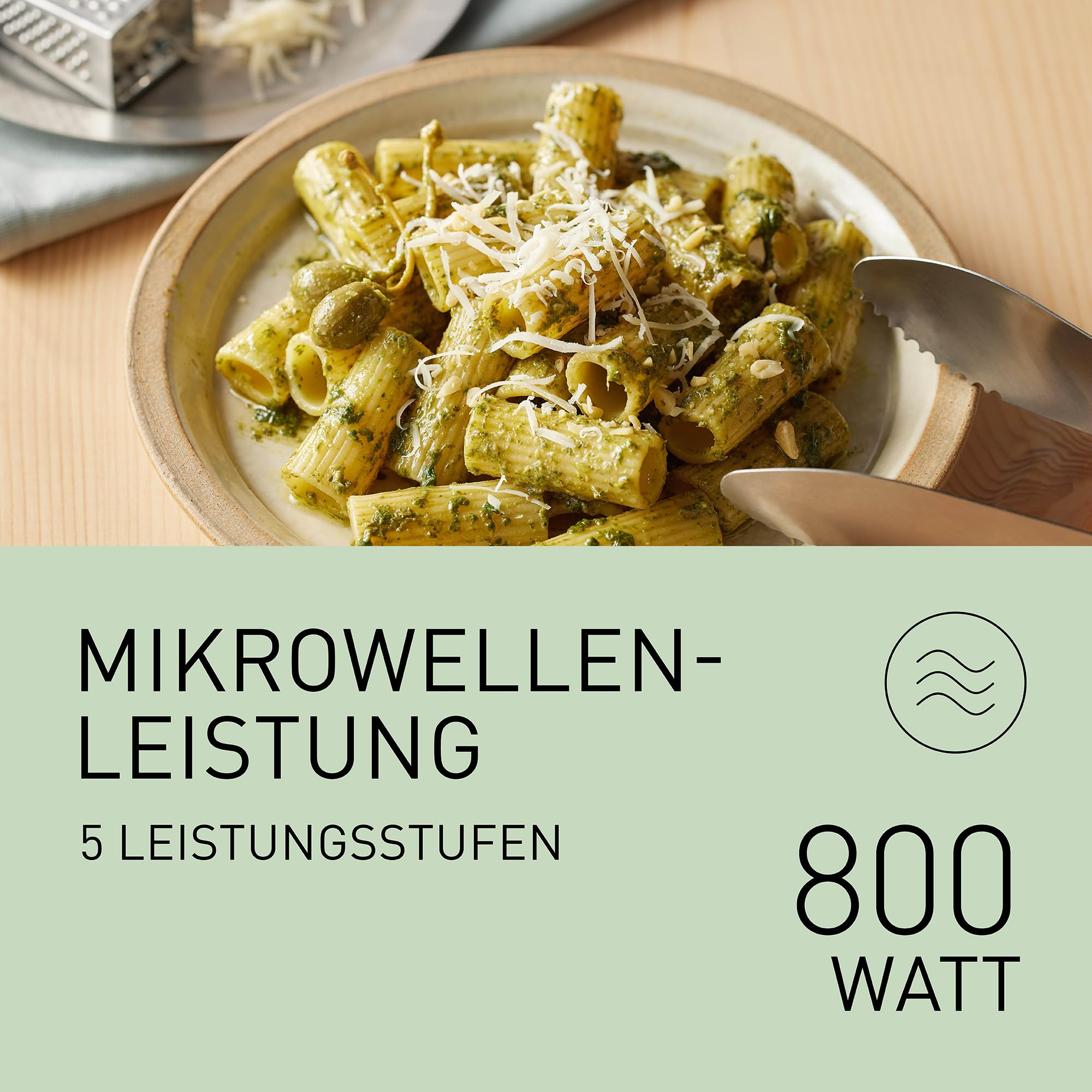 Rigatoni-Pasta mit Pesto und Käse in einer Schüssel, mit Textfeld für Mikrowellenleistung.