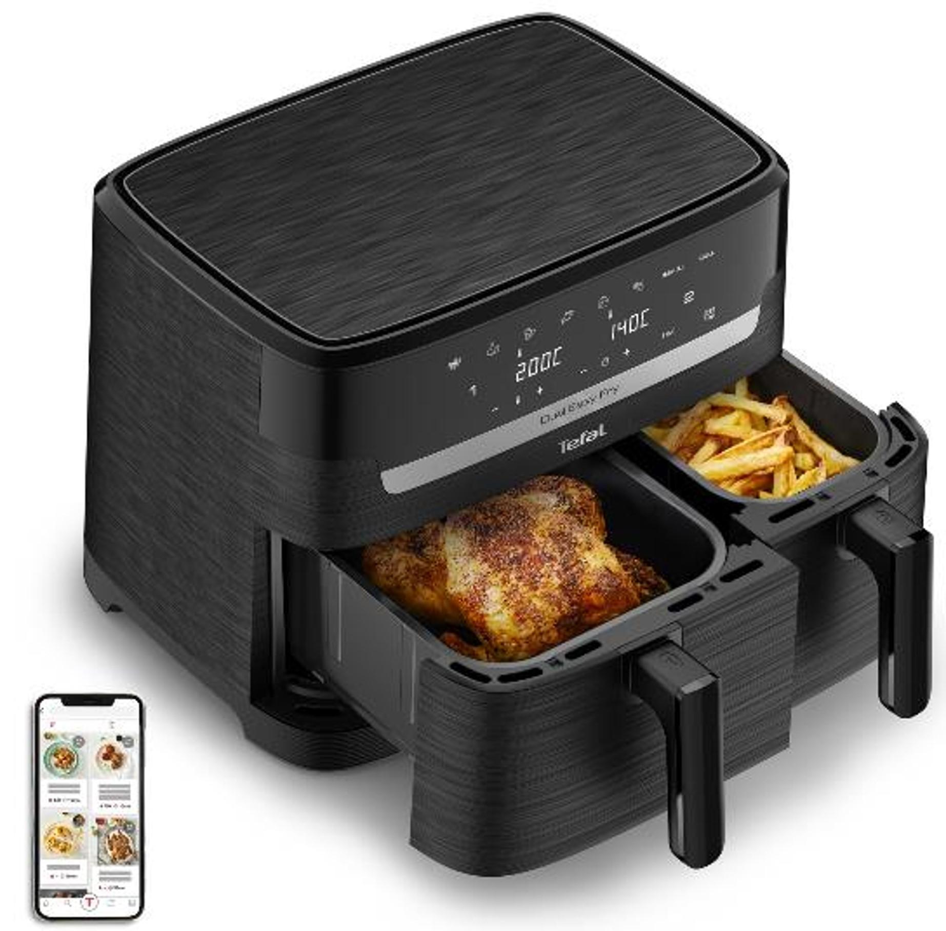 Friggitrice ad aria Tefal nera con due cassetti con pollo e patatine, accanto a uno smartphone.