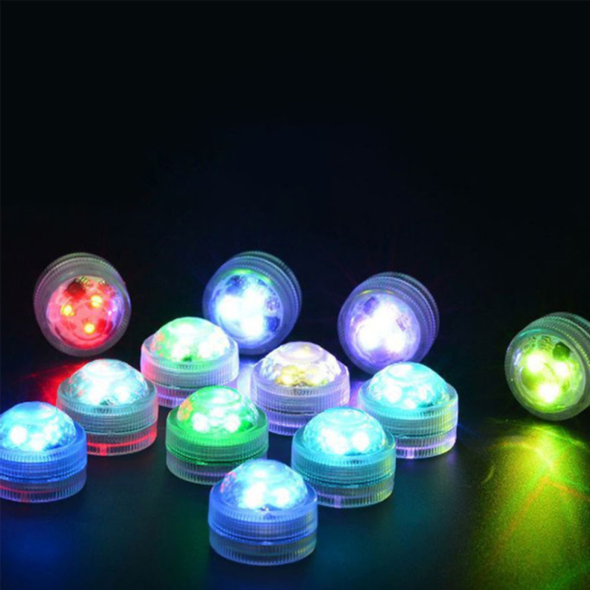 Mehrere kleine, runde, leuchtende LED-Leuchten in Rot, Grün, Blau und Weiß sind auf einer dunklen Oberfläche angeordnet.