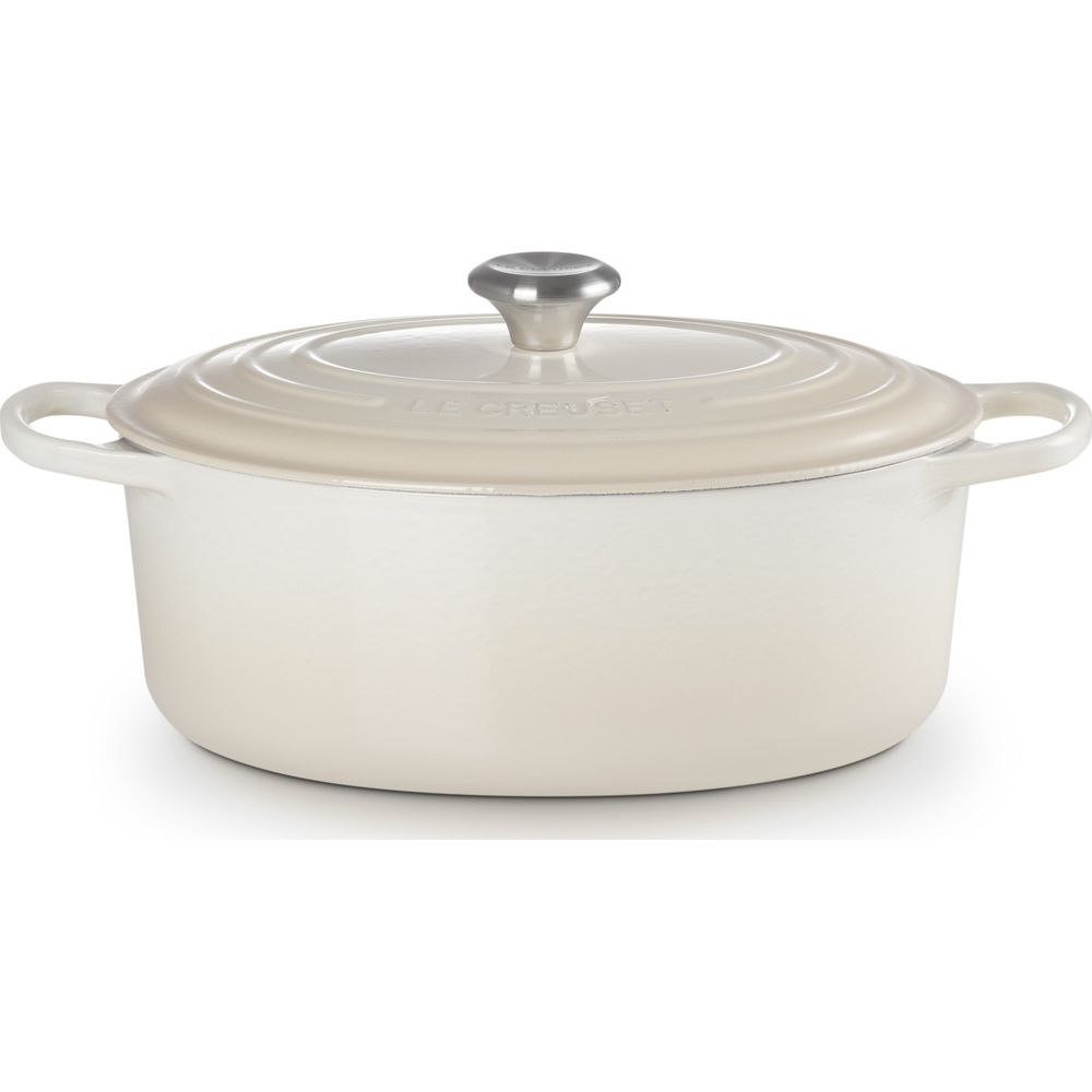 Cocotte en fonte couleur crème avec couvercle assorti et bouton en métal sur fond blanc.
