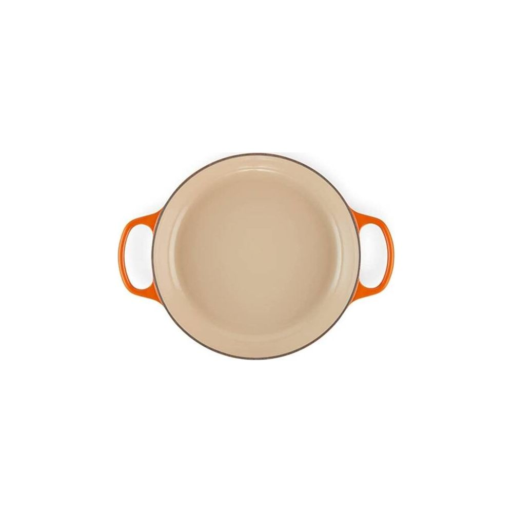 Une poêle en fonte orange avec un intérieur beige et deux poignées latérales sur fond blanc.