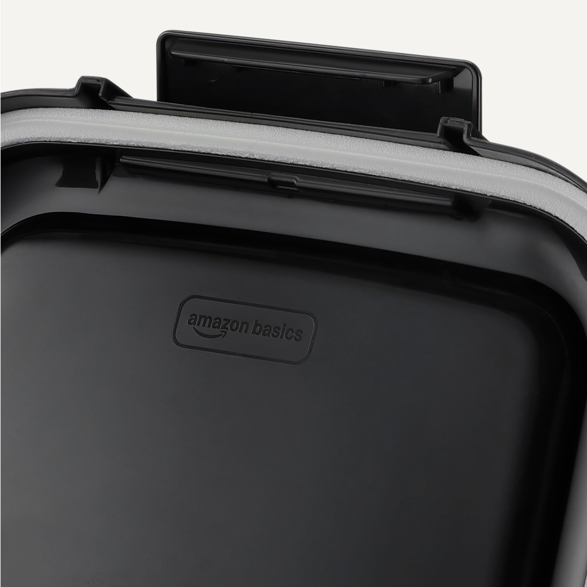 Primo piano di un coperchio nero per contenitore Amazon Basics con guarnizione grigia e chiusura.
