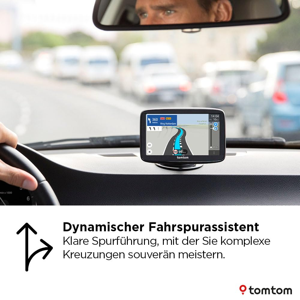 Un navigatore GPS TomTom sul cruscotto di un'auto, che mostra una mappa stradale, con traffico e conducente.