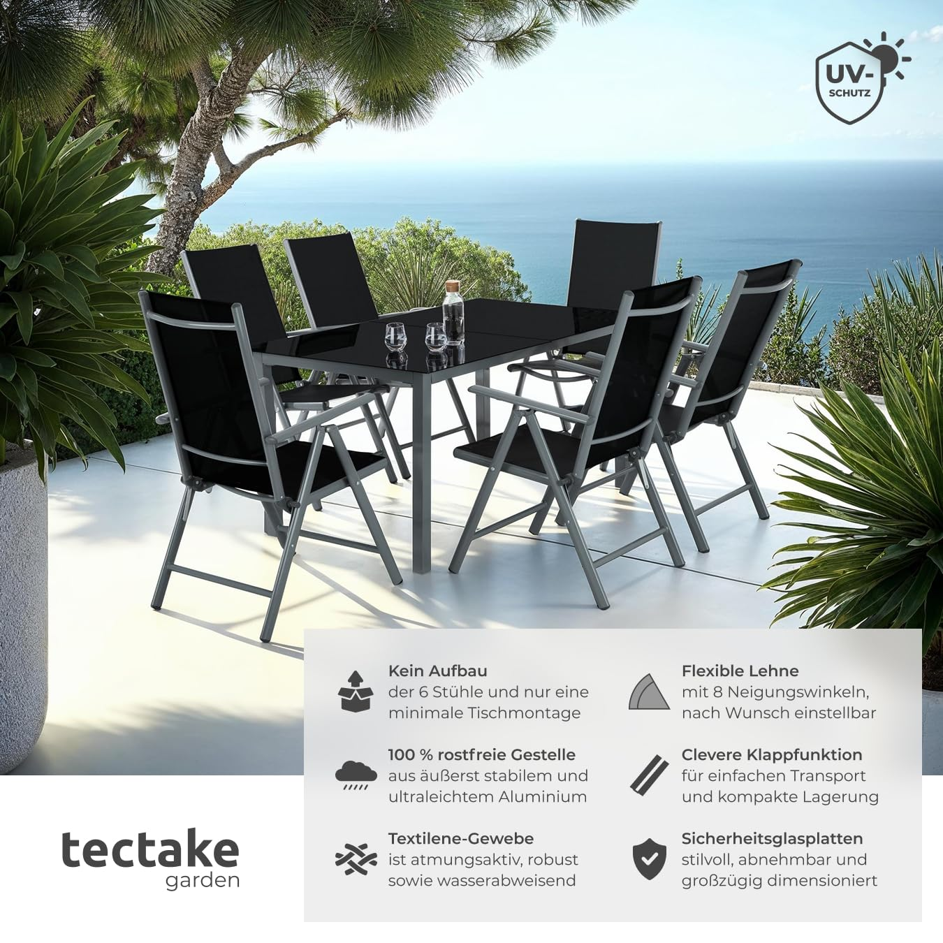 Eine schwarze Terrassen-Essgruppe mit sechs Stühlen auf einer sonnigen Terrasse mit Meerblick.