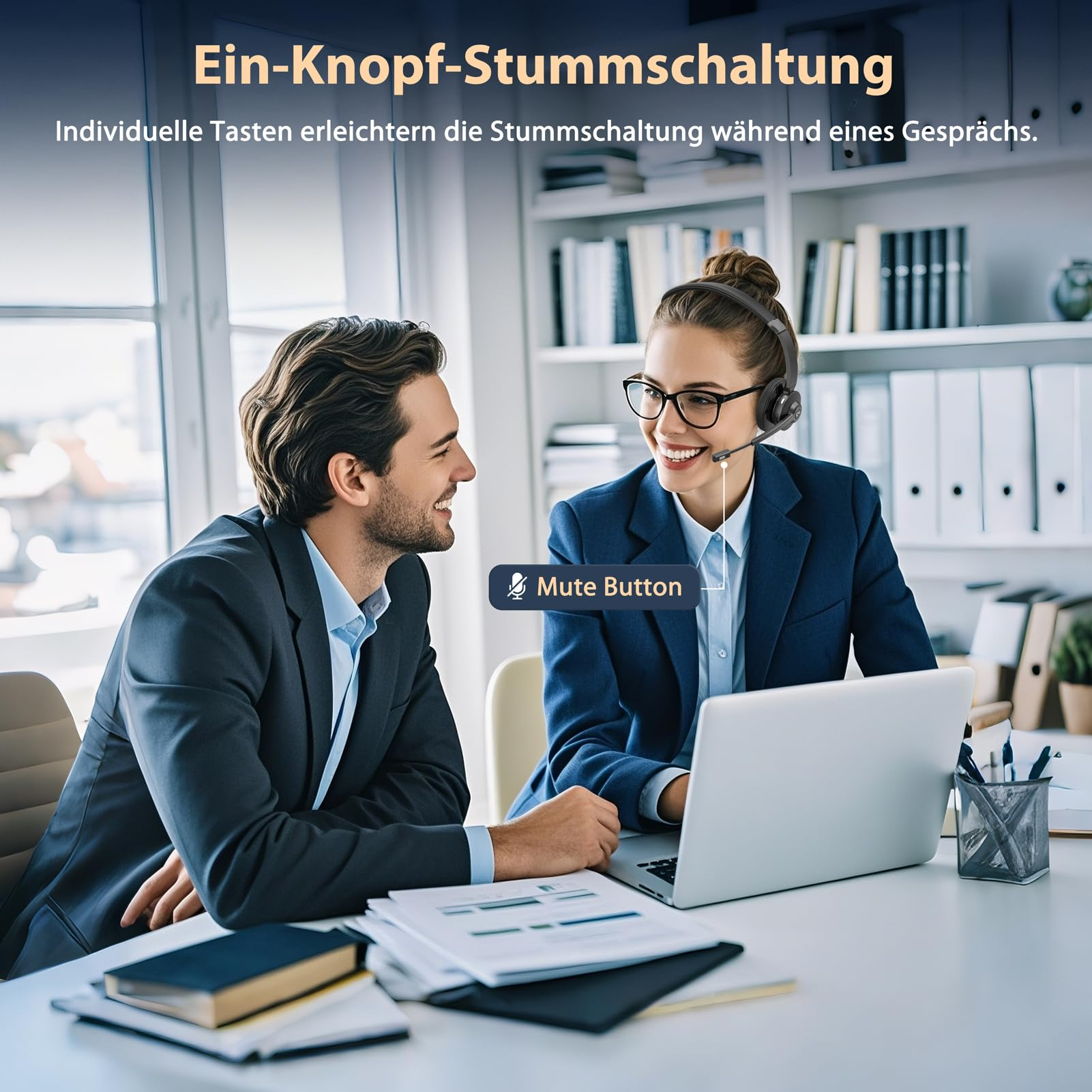 Büroangestellte in Anzügen lächeln an einem Schreibtisch mit Laptop. Die Frau trägt ein Headset.