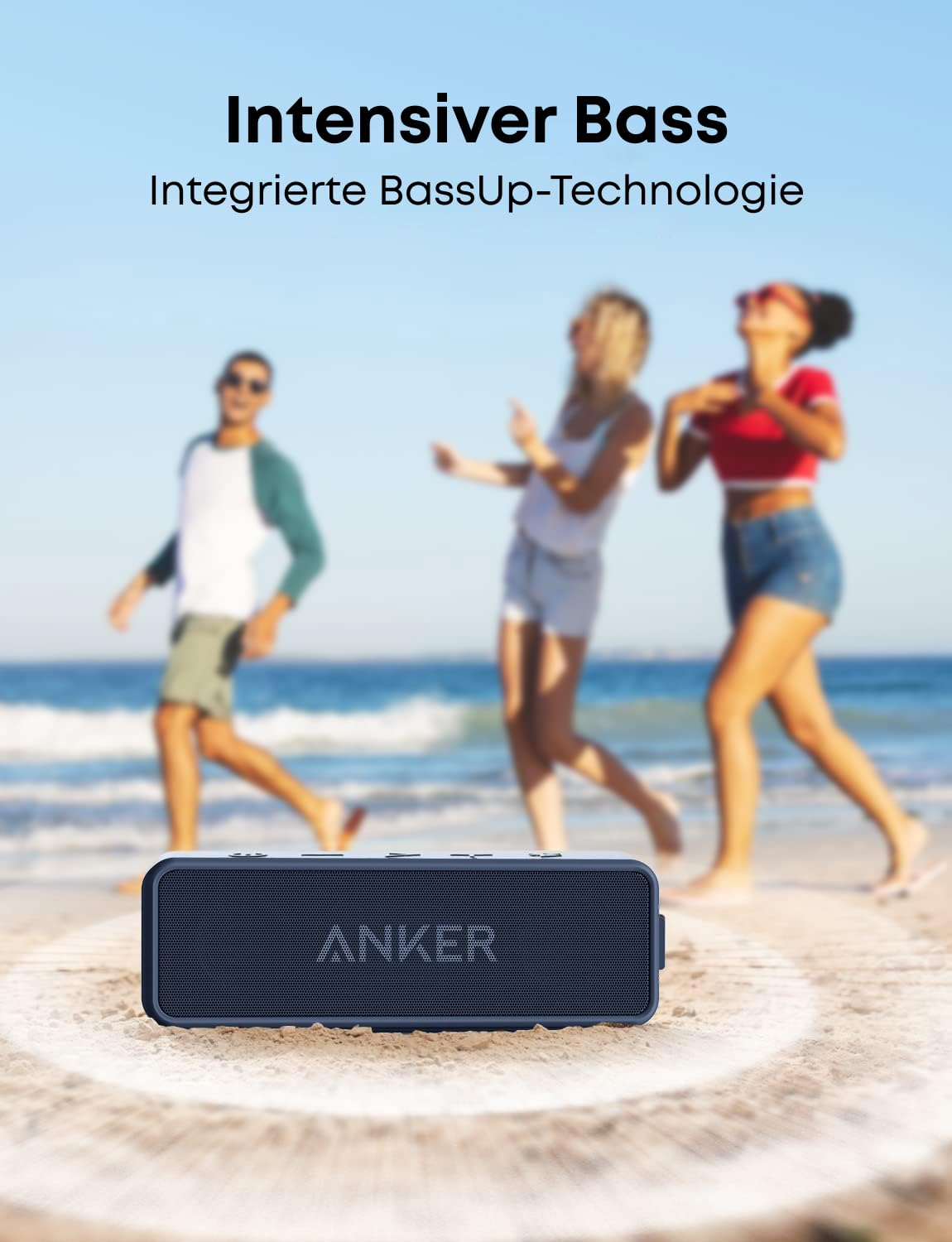 Une enceinte Bluetooth Anker bleue est sur la plage tandis que trois personnes dansent en arrière-plan.