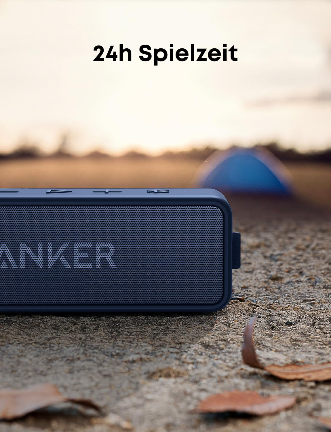 Une enceinte Anker bleue posée sur le sol à l'extérieur, avec une tente en arrière-plan et du texte au-dessus.