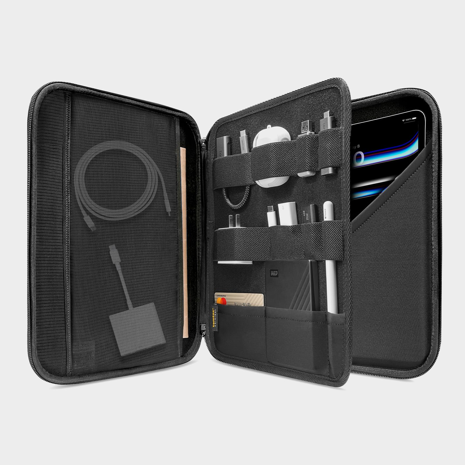 Ein offener schwarzer Organizer mit Kabeln, Zubehör und einem Tablet im Innenfach vor hellem Hintergrund.