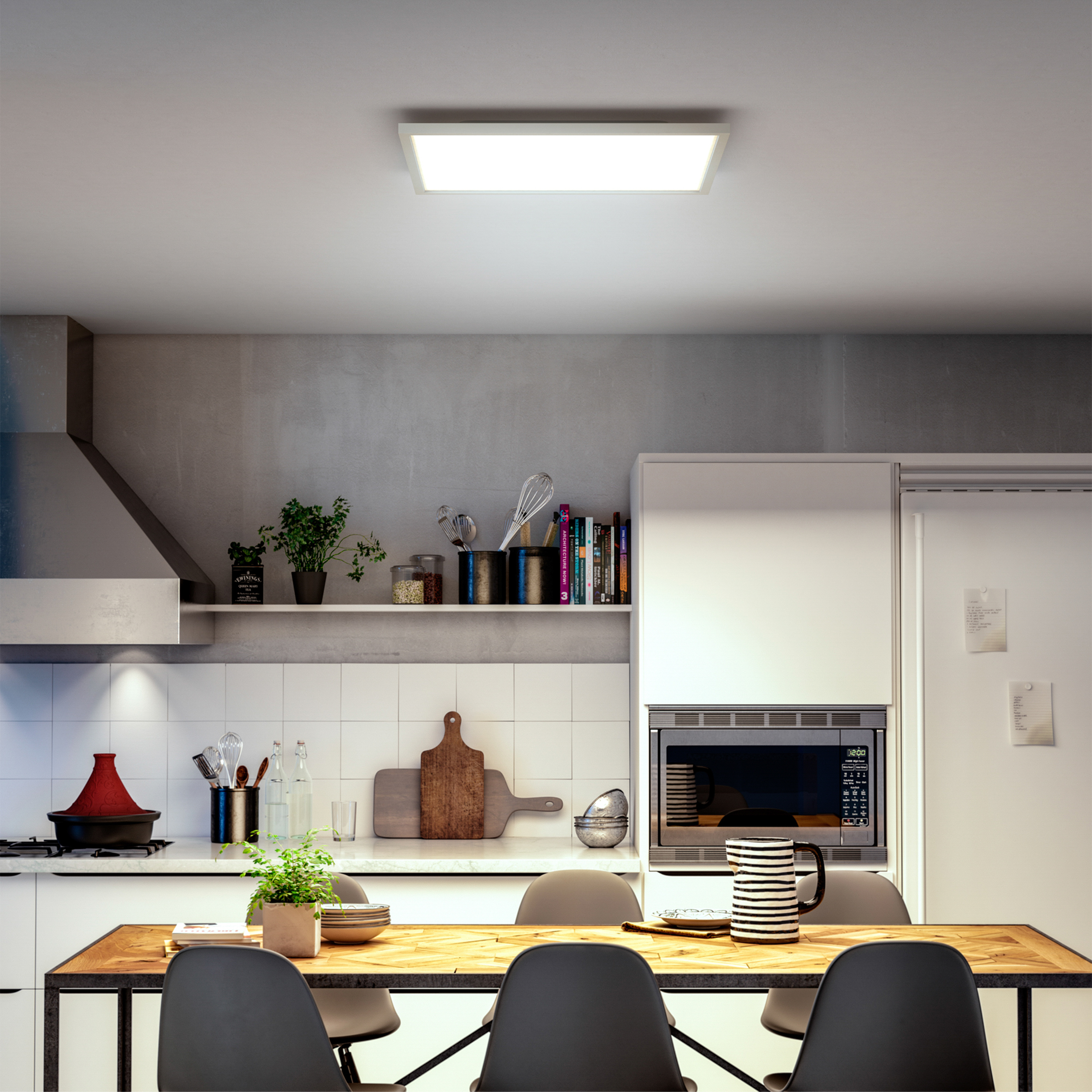 Cucina moderna con tavolo da pranzo in legno, sedie grigie, armadietti bianchi, ripiani con utensili e lampada da soffitto.