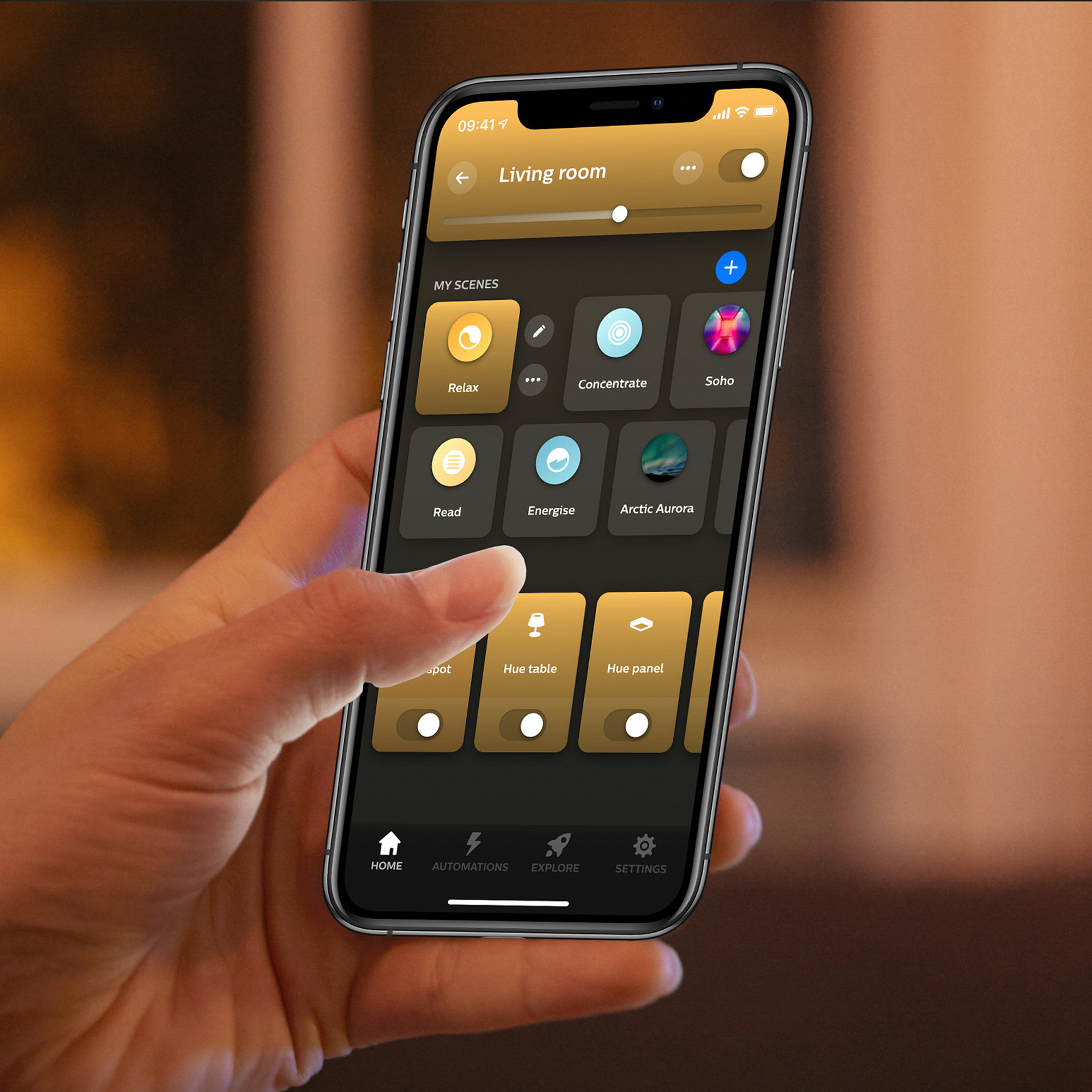 Una mano tiene uno smartphone che mostra un'app di controllo dell'illuminazione smart.