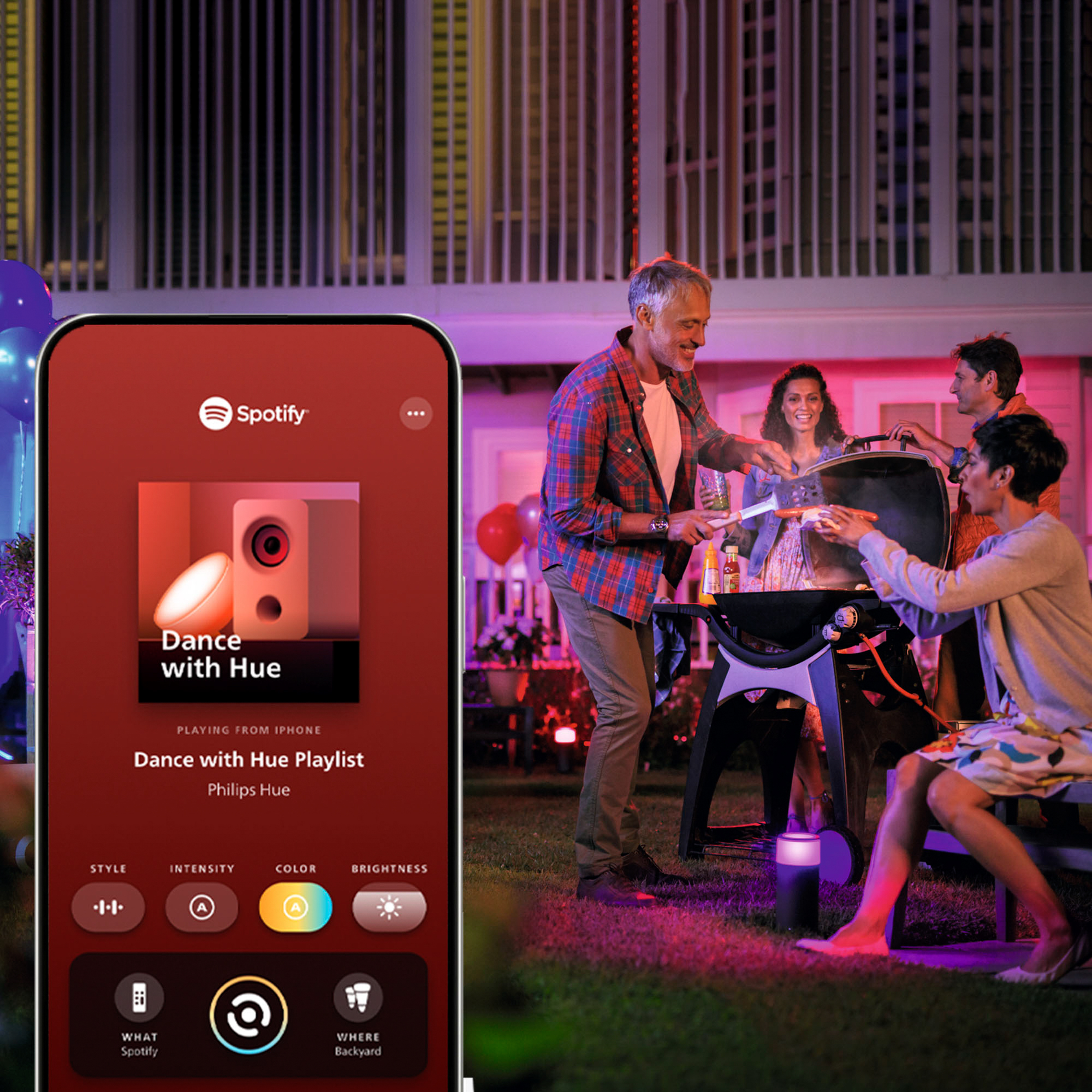 Uno smartphone mostra Spotify mentre alcune persone fanno un barbecue di notte.