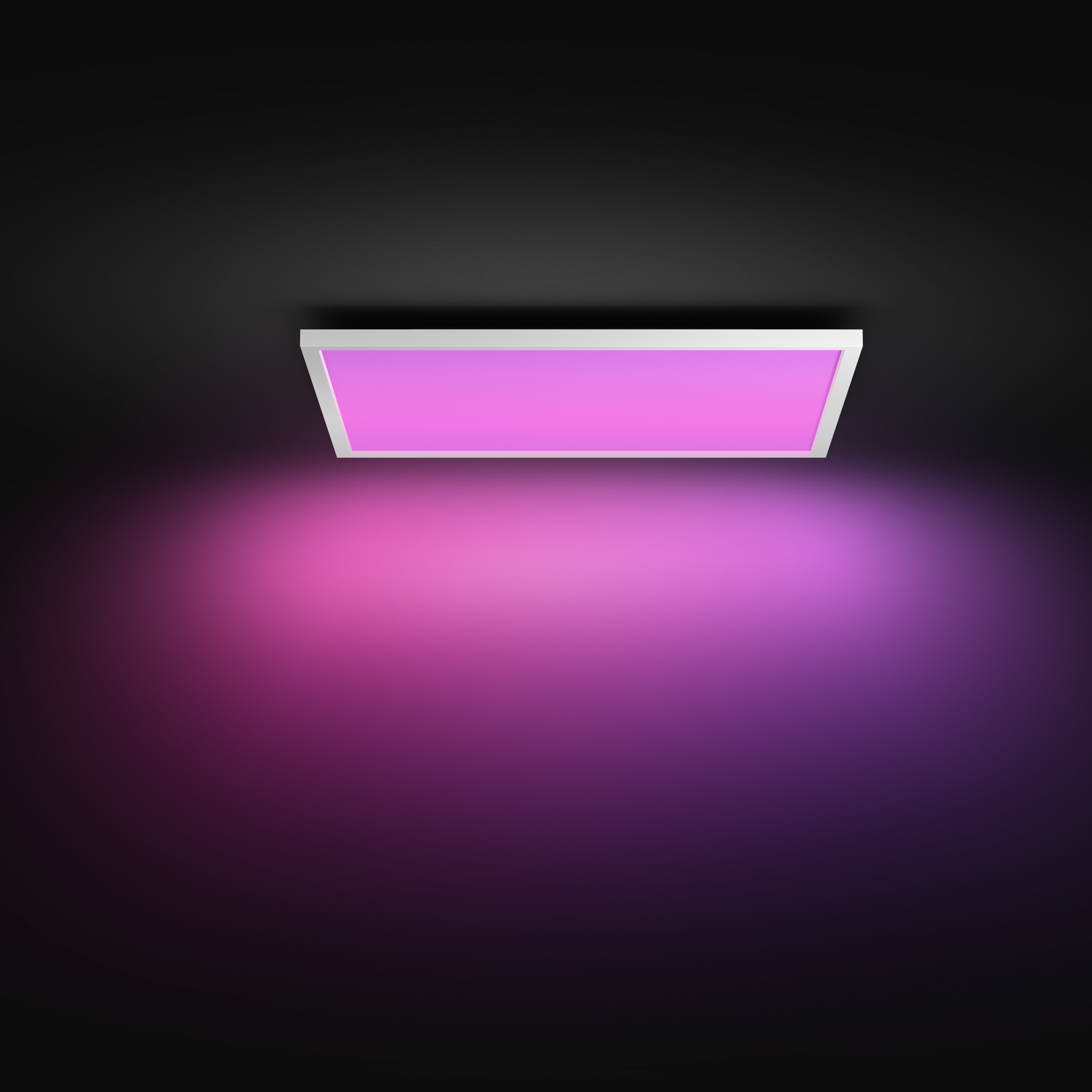 Un panneau LED rectangulaire blanc sur un plafond sombre projette une lueur vibrante rose et violette.