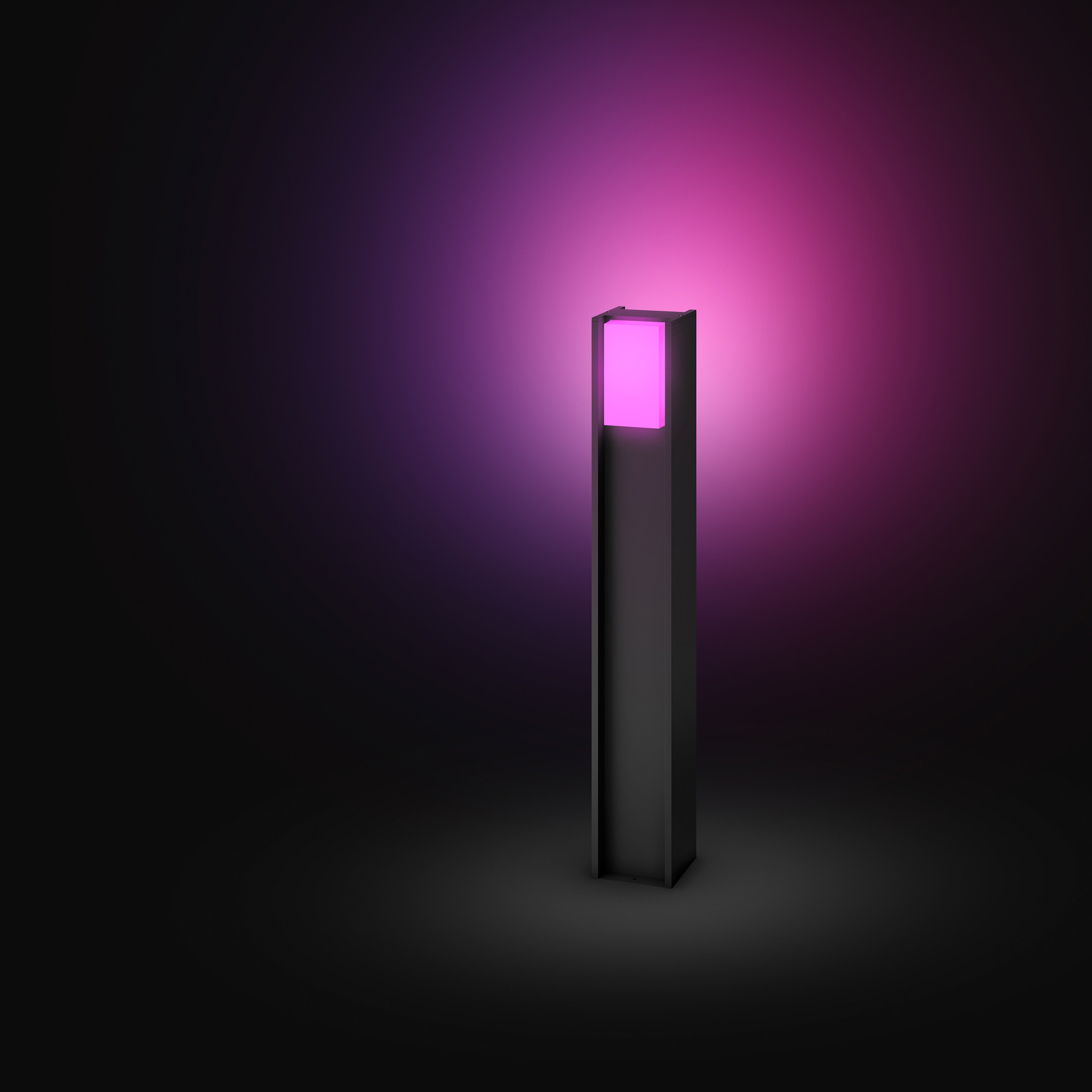 Un lampione da esterno moderno nero emette una vivace luce rosa su uno sfondo scuro.