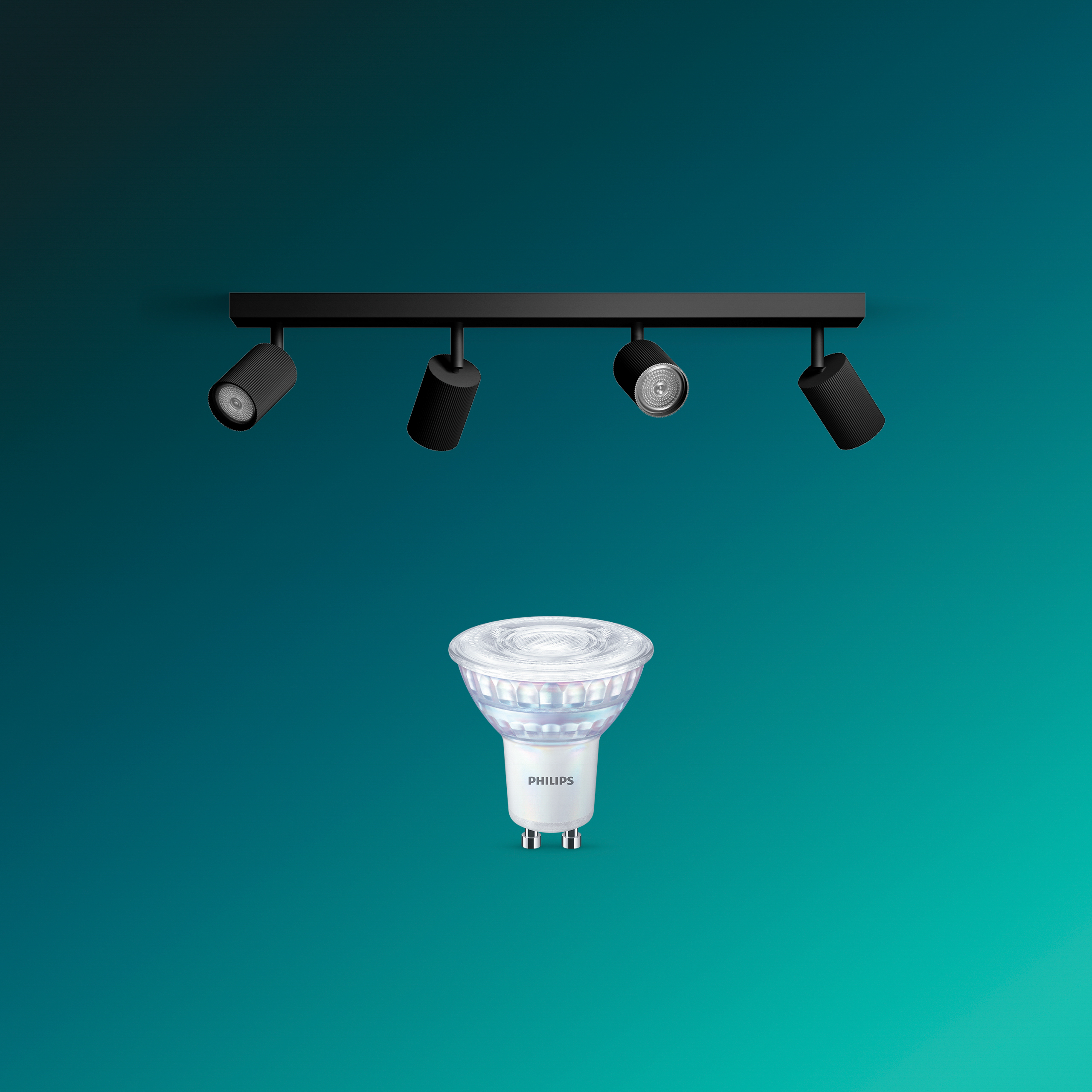Eine Philips LED-Strahlerlampe steht unter einer schwarzen Schiene mit vier verstellbaren Strahlern vor türkisfarbenem Grund.