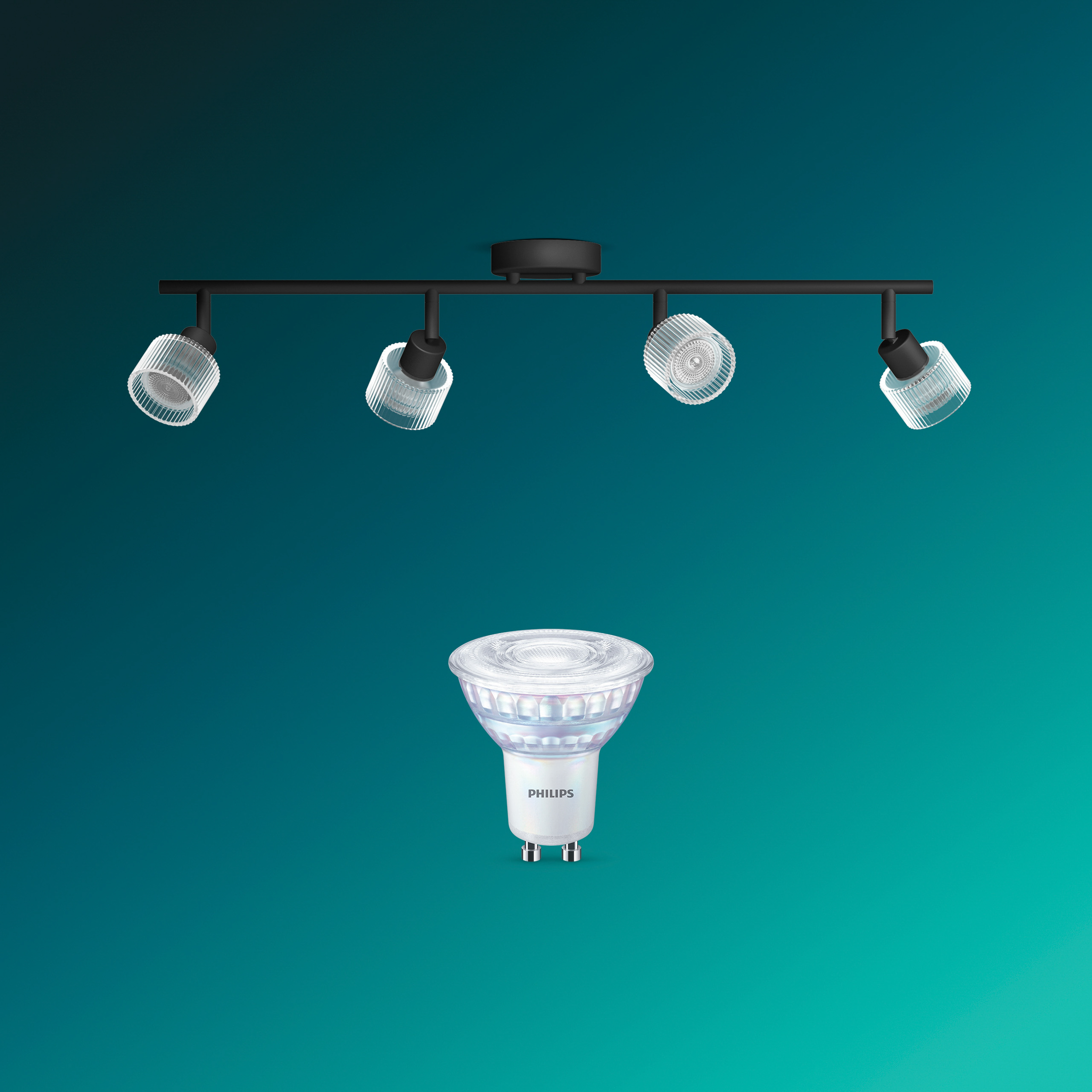 Eine schwarze Deckenleuchte mit vier gerippten Glasspots und eine separate Philips Glühbirne auf teal Hintergrund.