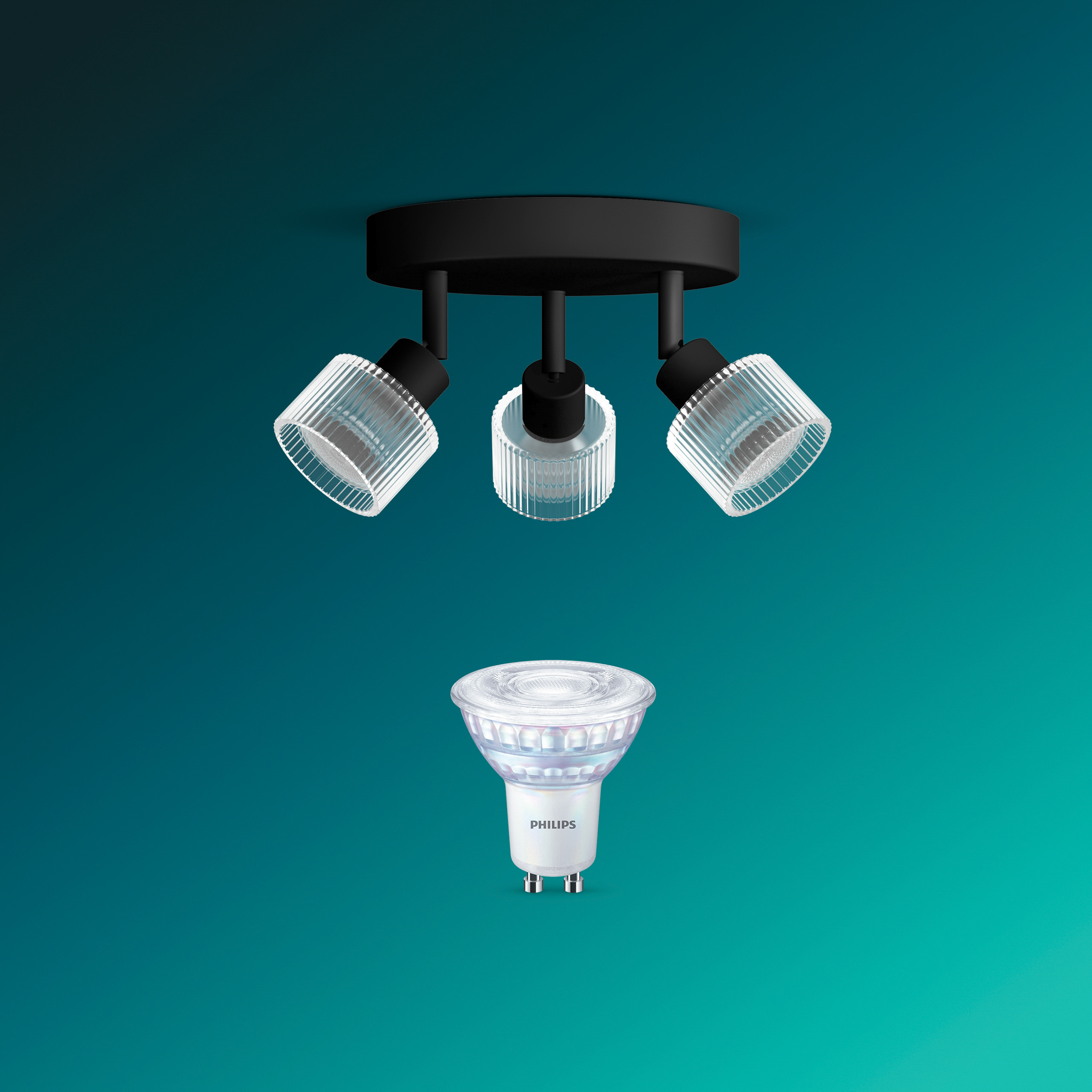 Eine schwarze Deckenleuchte mit drei gerippten Glasschirmen und einer Philips LED-Lampe vor tealblauem Hintergrund.