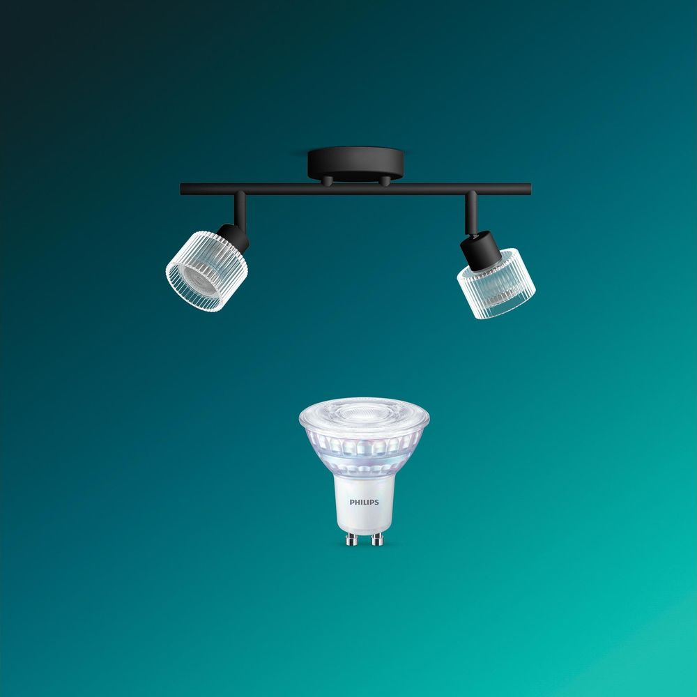 Eine schwarze Doppel-Spotlight-Leuchte über einer einzelnen Philips LED-Lampe vor tealblauem Hintergrund.