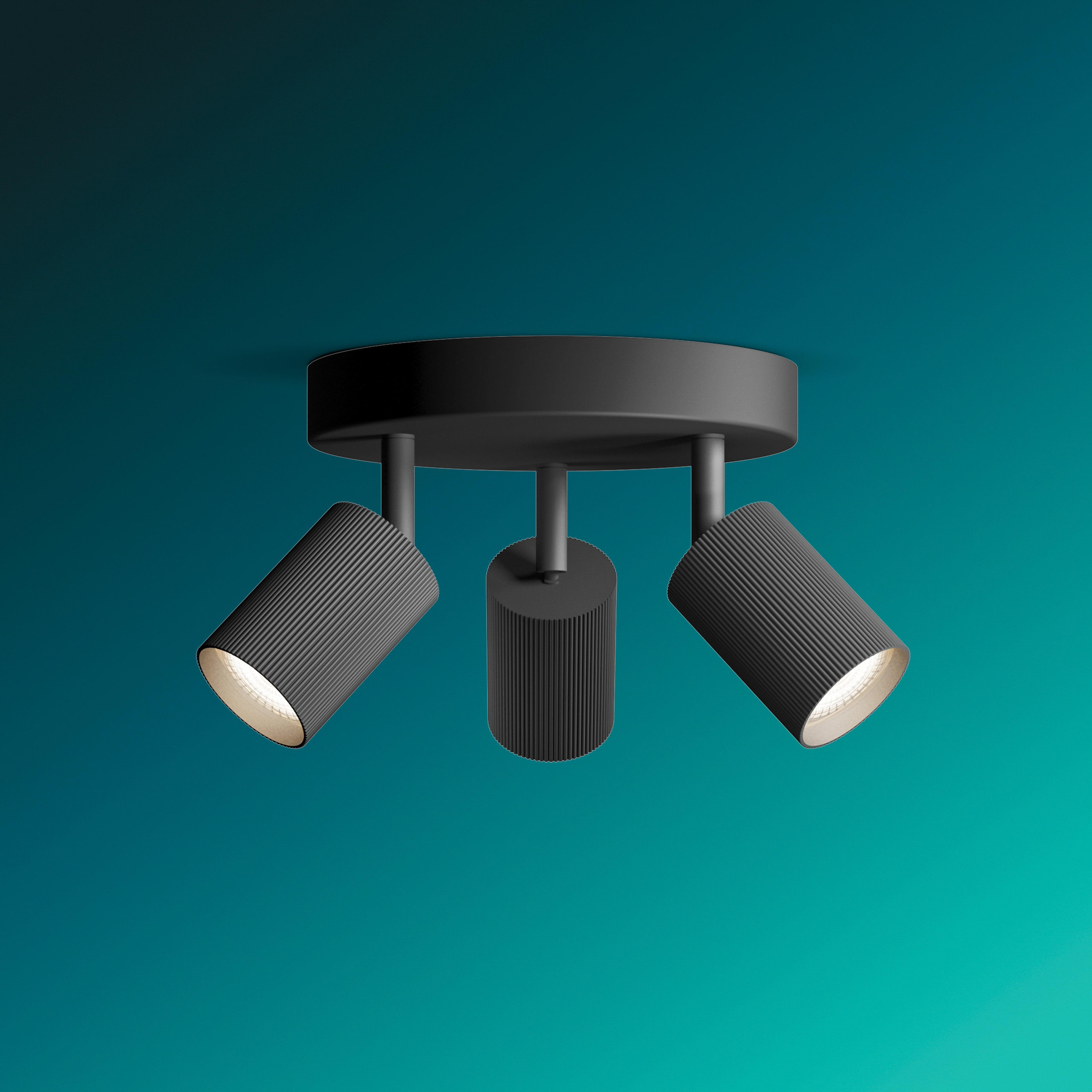 Schwarze Deckenlampe mit drei zylindrischen Strahlern vor einem türkisfarbenen Hintergrund.
