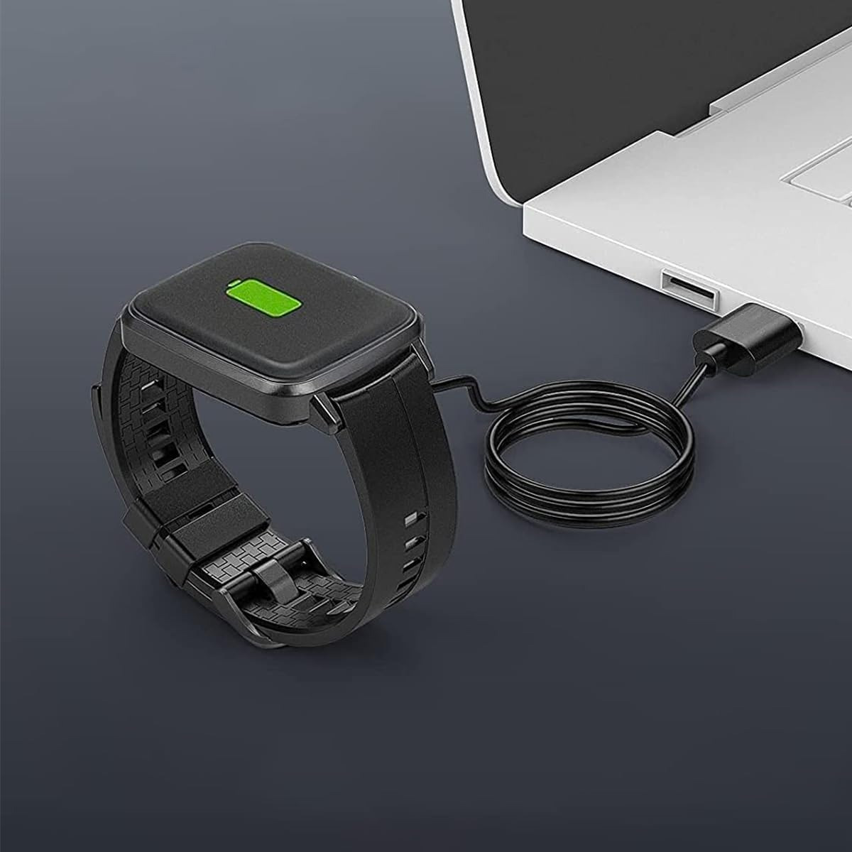 Eine schwarze Smartwatch lädt mit einem Kabel, das an einen weißen Laptop angeschlossen ist.