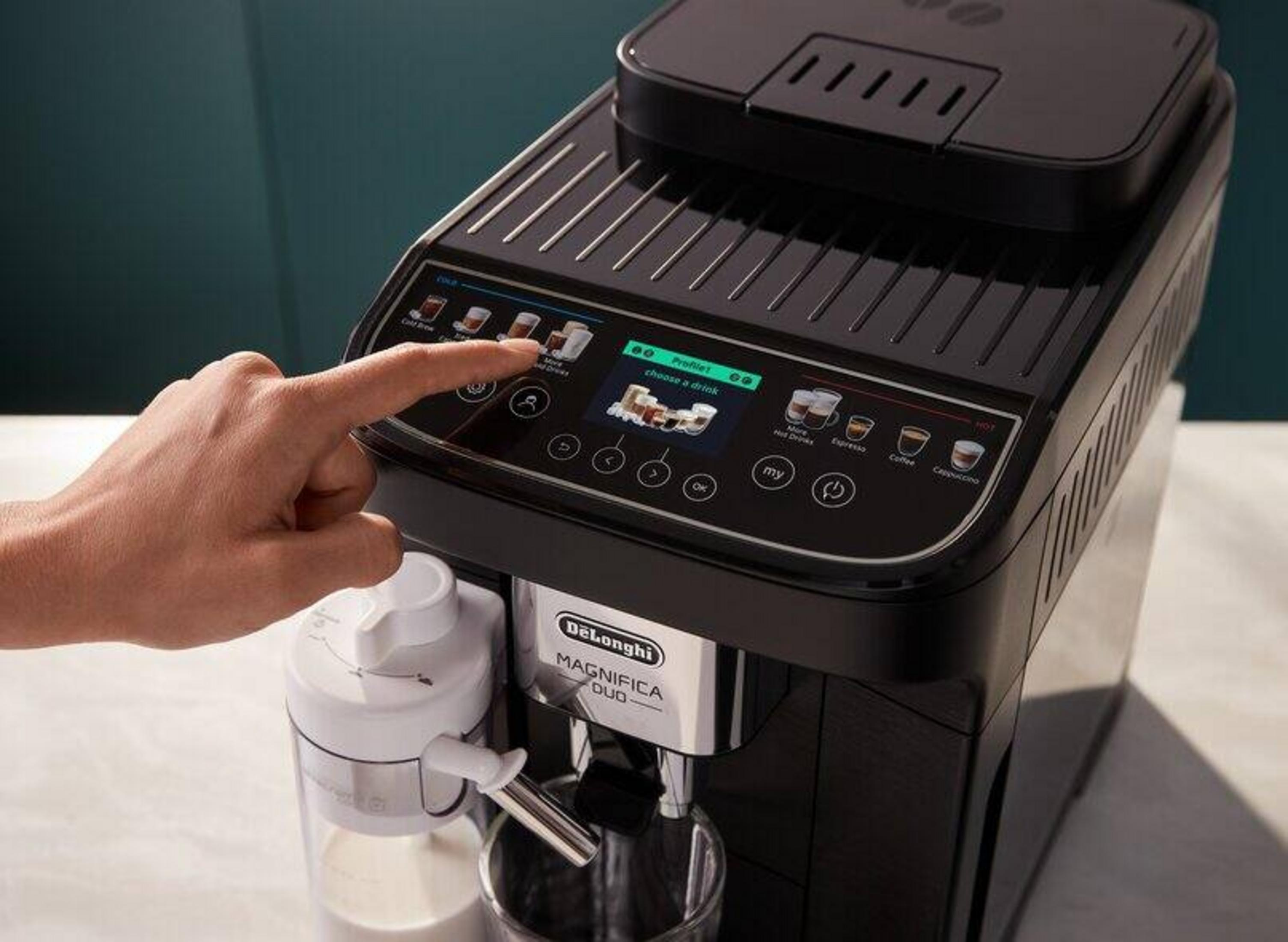 Una mano interagisce con il display touch di una macchina da caffè nera DeLonghi Magnifica Duo.