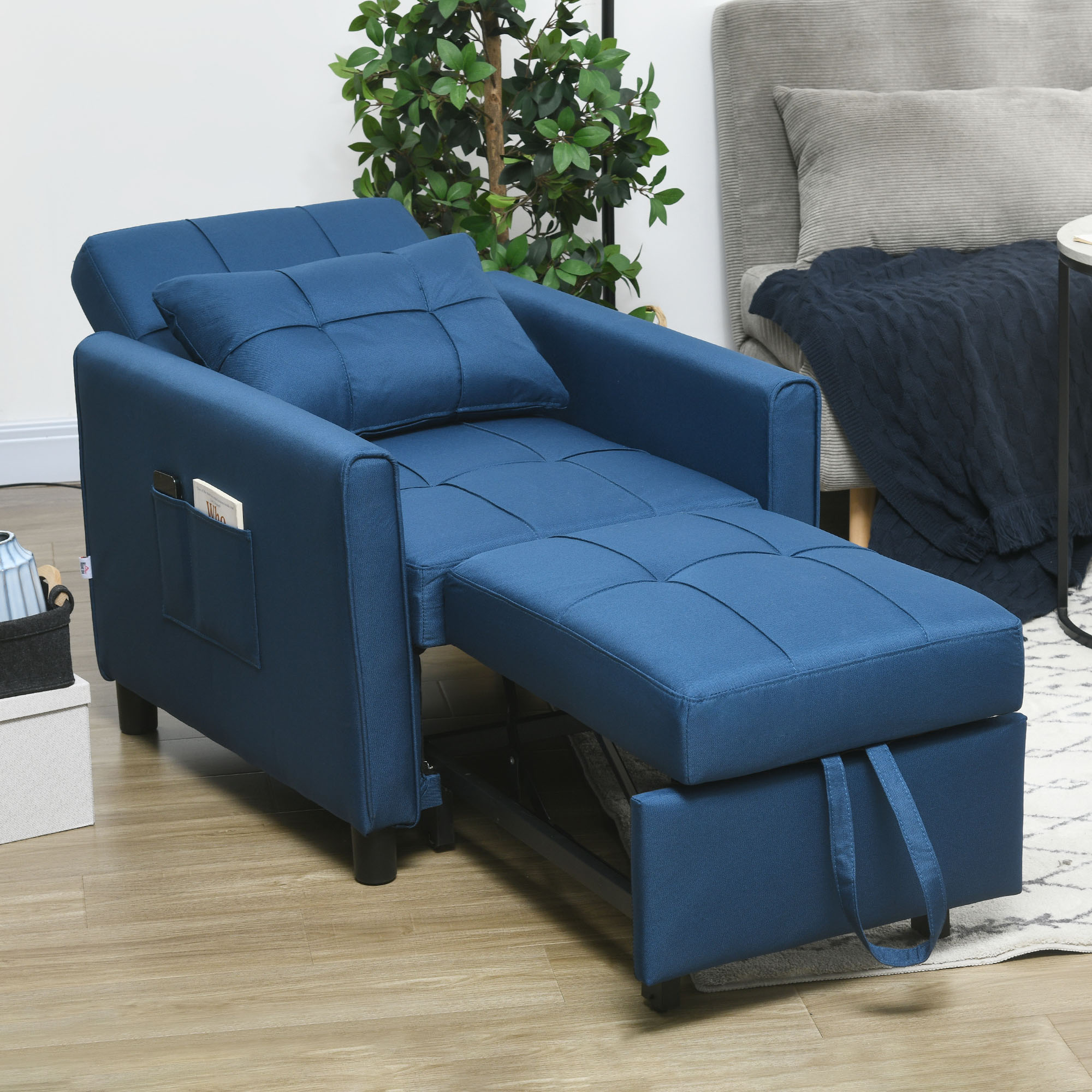 Una poltrona pieghevole blu in un soggiorno moderno con cuscino, poggiapiedi estraibile e tasca laterale.