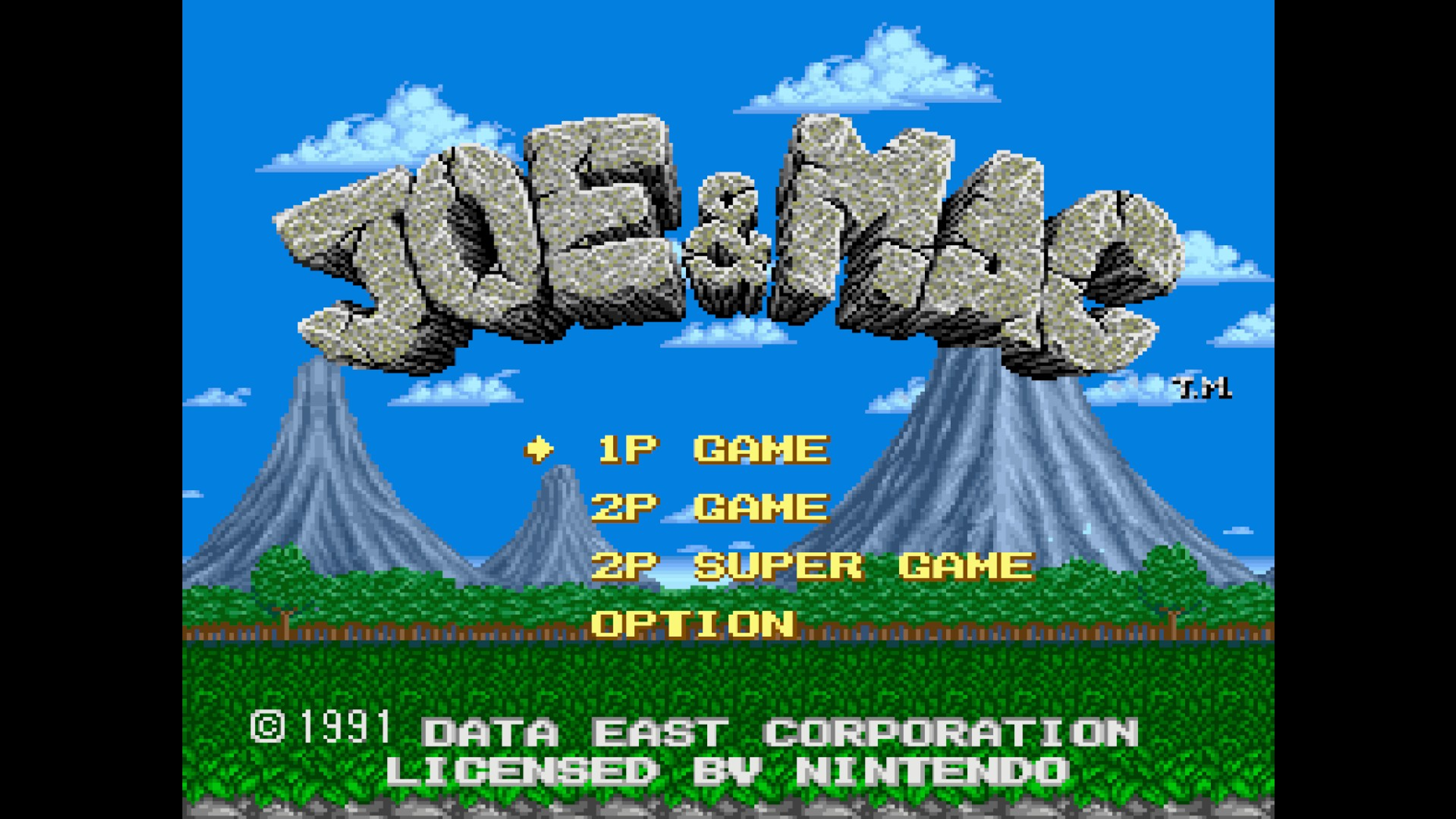 Schermata del titolo del videogioco Joe & Mac con un logo roccioso su montagne e cielo blu.