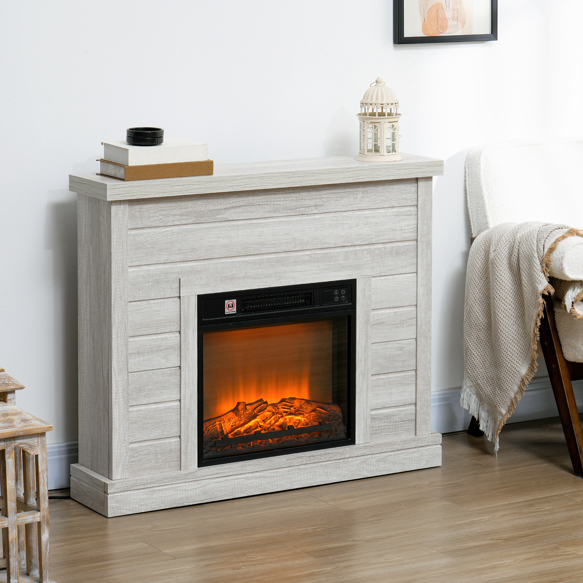Una chimenea eléctrica blanca contra una pared junto a un sillón con manta.